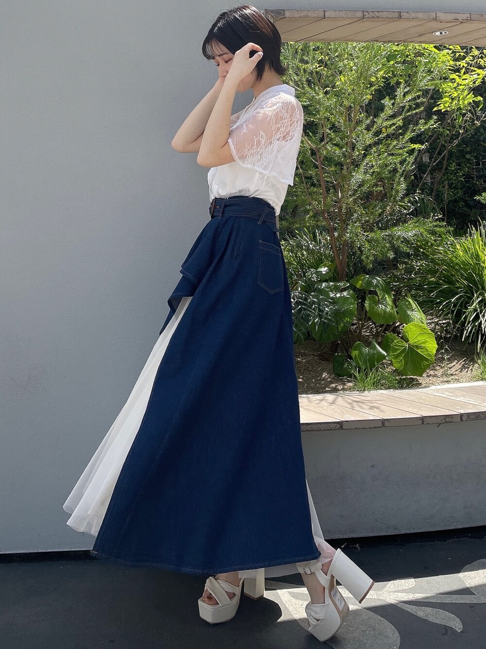 ホワイト系のシャツ/ブラウス、ブルー系のスカート、ホワイト系のサンダルを着用したレディースの春コーディネートの2枚目の写真