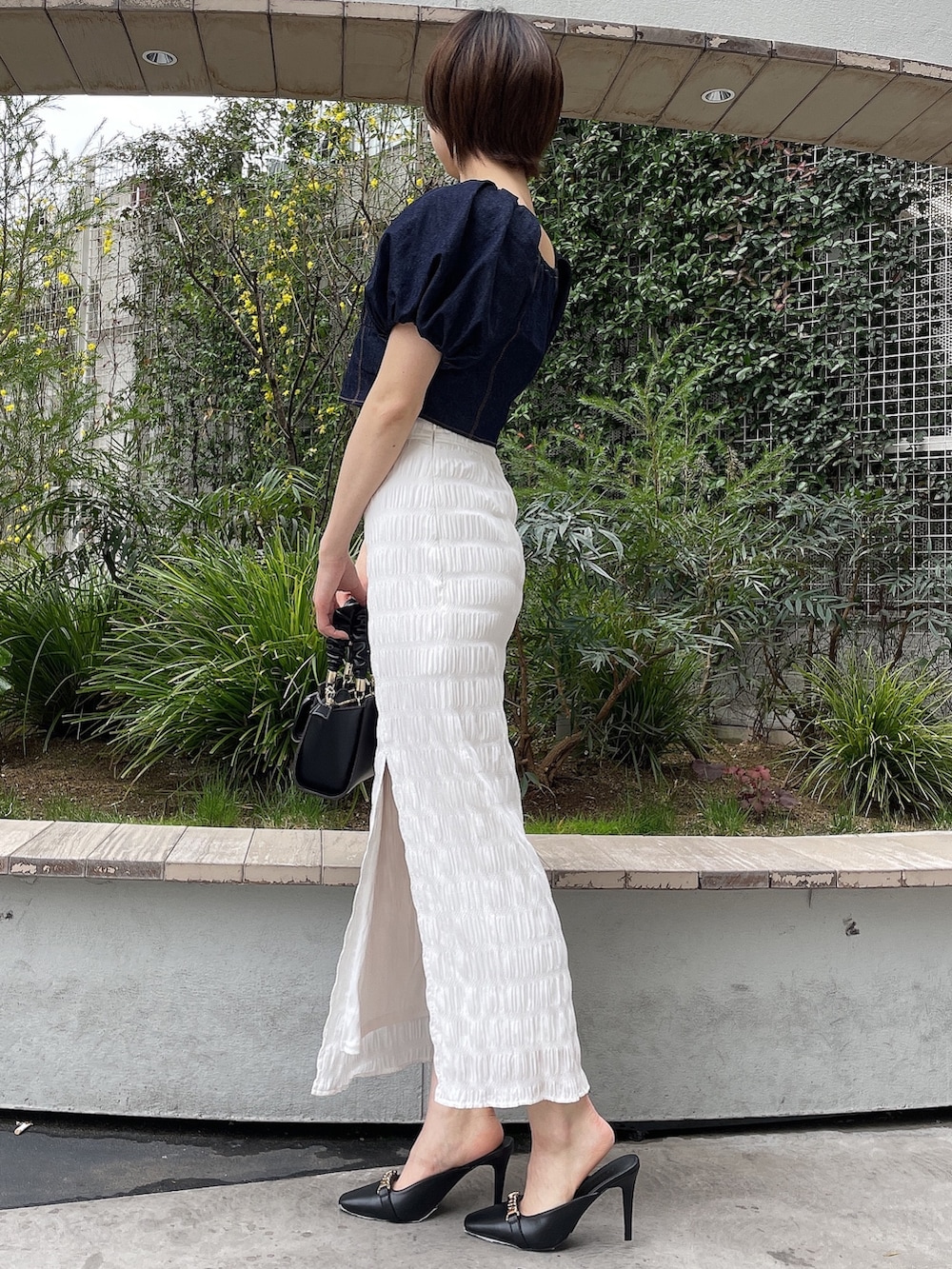 ブルー系のシャツ/ブラウス、ブラック系のハンドバッグ、ブラック系のサンダルを着用したレディースの春コーディネートの3枚目の写真