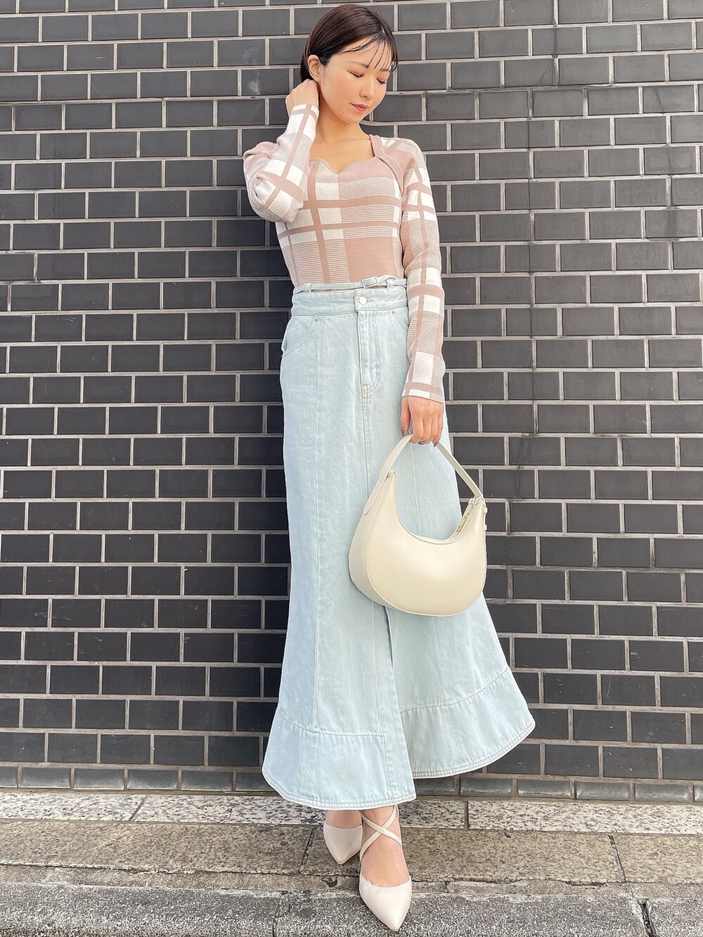 その他のニット/セーター、ホワイト系のハンドバッグ、ブルー系のデニムスカートを着用したレディースの冬コーディネートの2枚目の写真