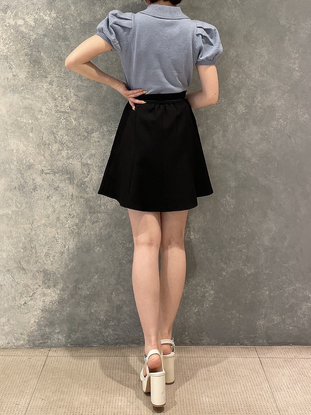 ホワイト系のサンダル、ブルー系のニット/セーター、ブラック系のスカートを着用したレディースの夏コーディネートの3枚目の写真