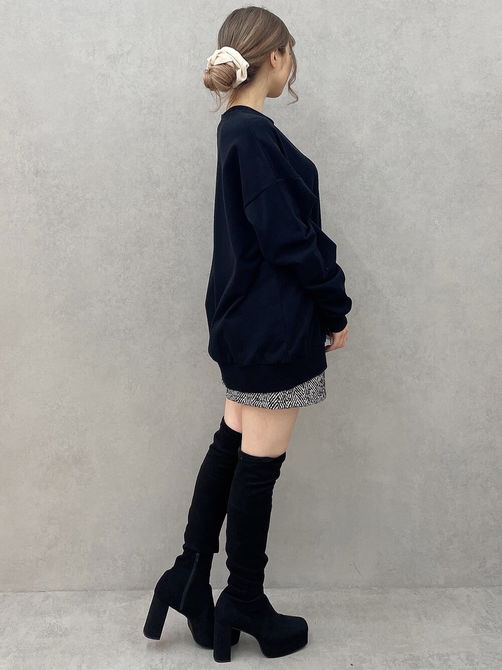 ブラック系のスウェット、ブラック系のブーツ、ブラック系のその他パンツを着用したレディースの秋コーディネートの2枚目の写真