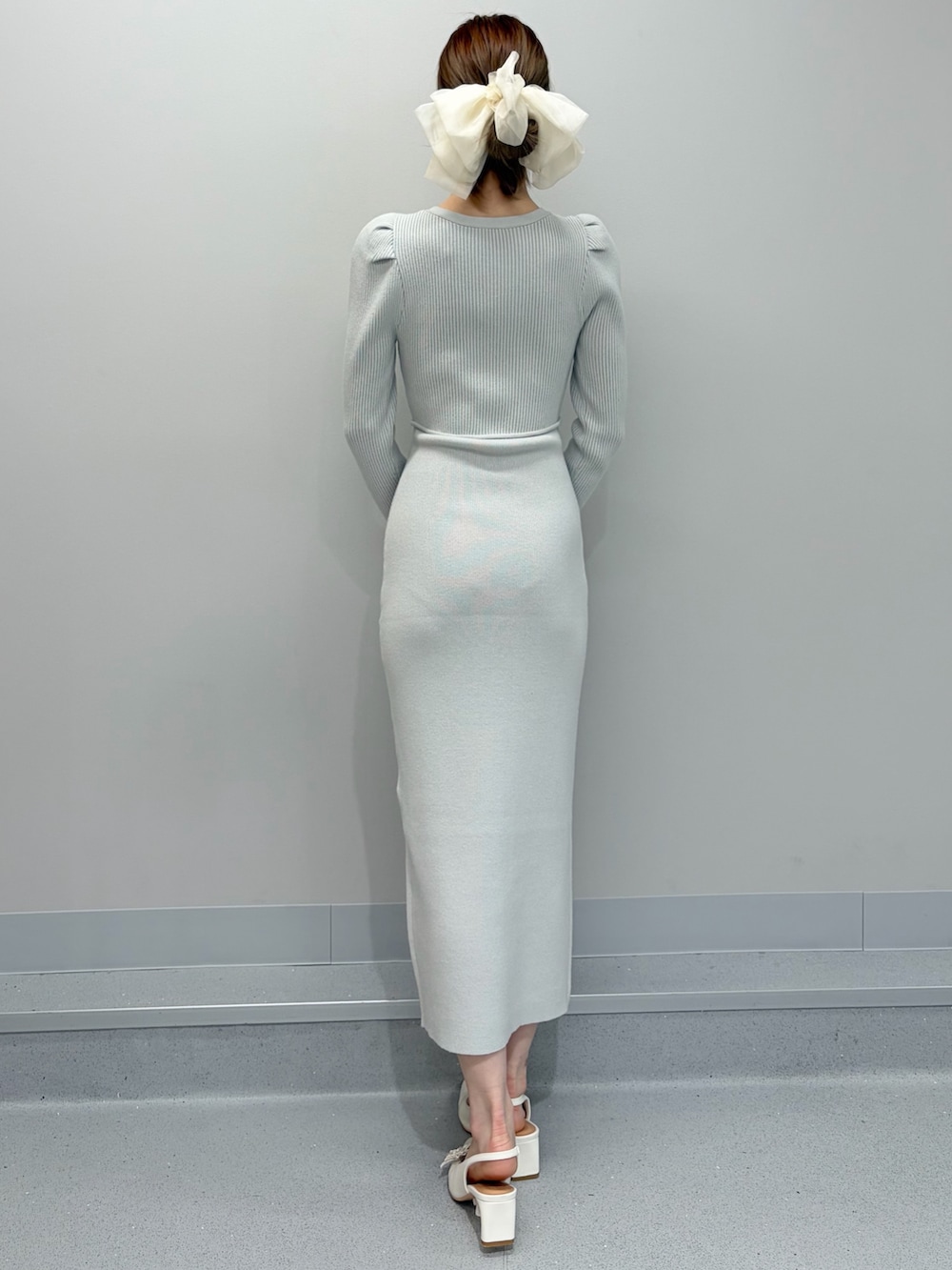 ホワイト系のライダースジャケット、ホワイト系のパンプス、グリーン系のワンピースを着用したレディースの冬コーディネートの4枚目の写真