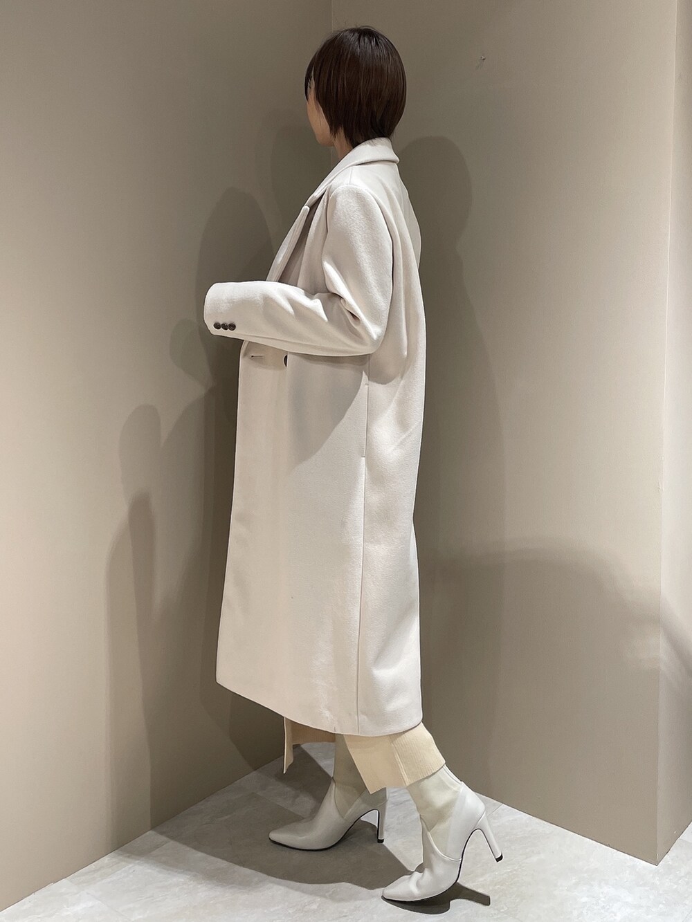 ホワイト系のチェスターコート、ホワイト系のブーツ、ホワイト系のワンピースを着用したレディースの夏コーディネートの4枚目の写真