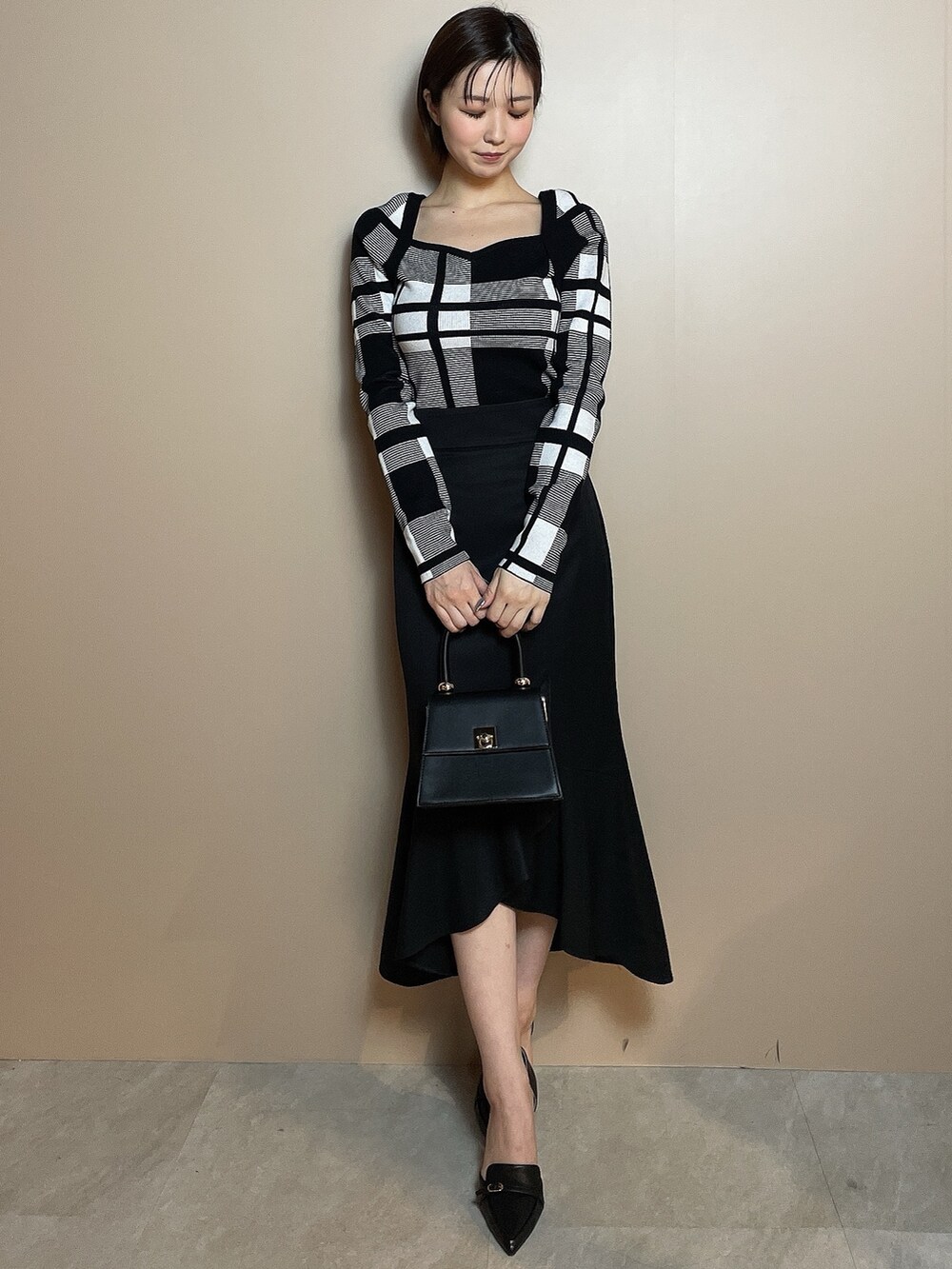 その他のニット/セーター、ブラック系のスカート、ブラック系のパンプスを着用したレディースの冬コーディネートの2枚目の写真