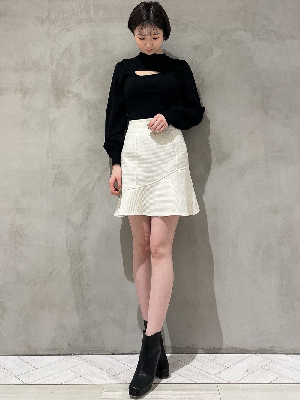 ホワイト系のテーラードジャケット、ホワイト系のスカート、ブラック系のニット/セーターを着用したレディースの冬コーディネートの4枚目の写真