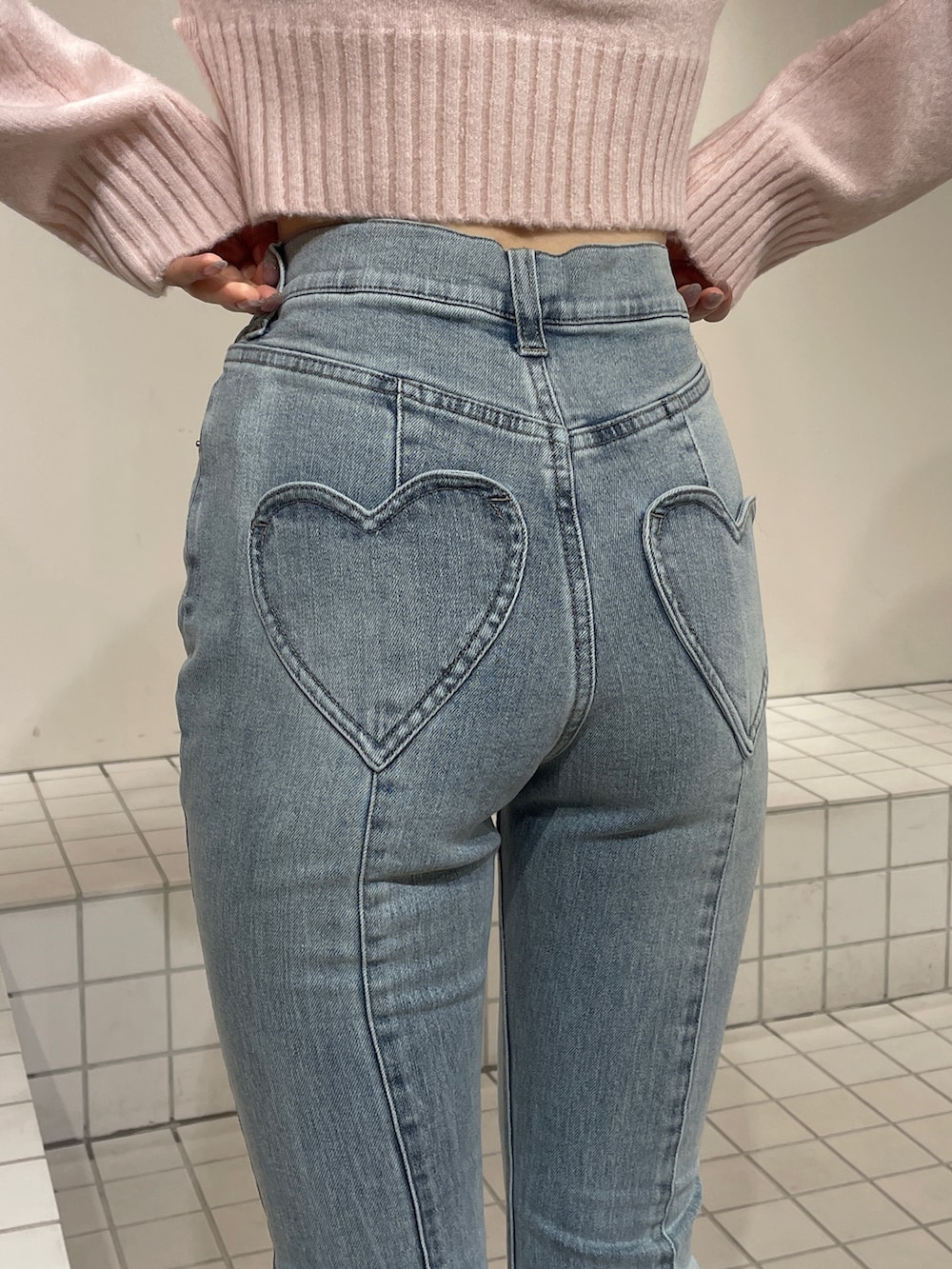 レッド系のニット/セーター、ブルー系のデニムパンツ、ホワイト系のブーツを着用したレディースの冬コーディネートの7枚目の写真