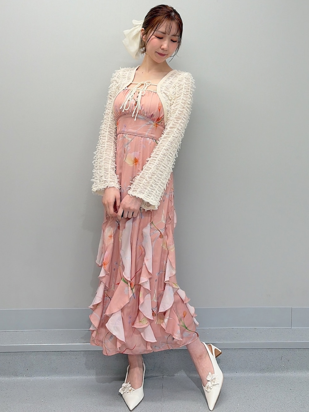 ホワイト系のパンプス、オレンジ系のワンピース、ホワイト系のバレッタ/ヘアクリップを着用したレディースの冬コーディネートの3枚目の写真