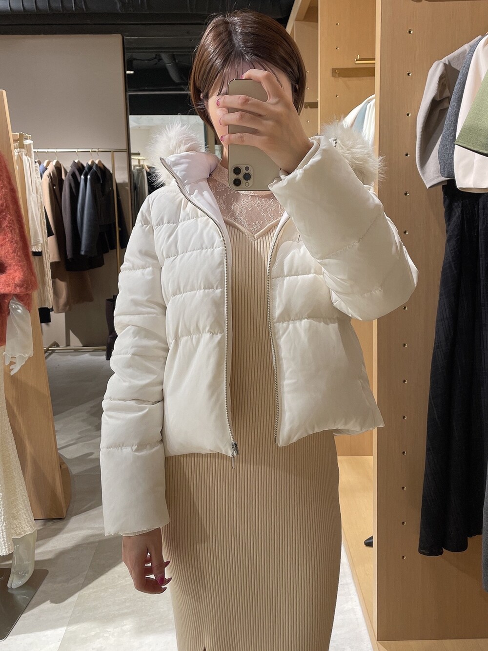 ホワイト系のダウンジャケット/コート、ホワイト系のワンピース、ホワイト系のブーツを着用したレディースの秋コーディネートの5枚目の写真