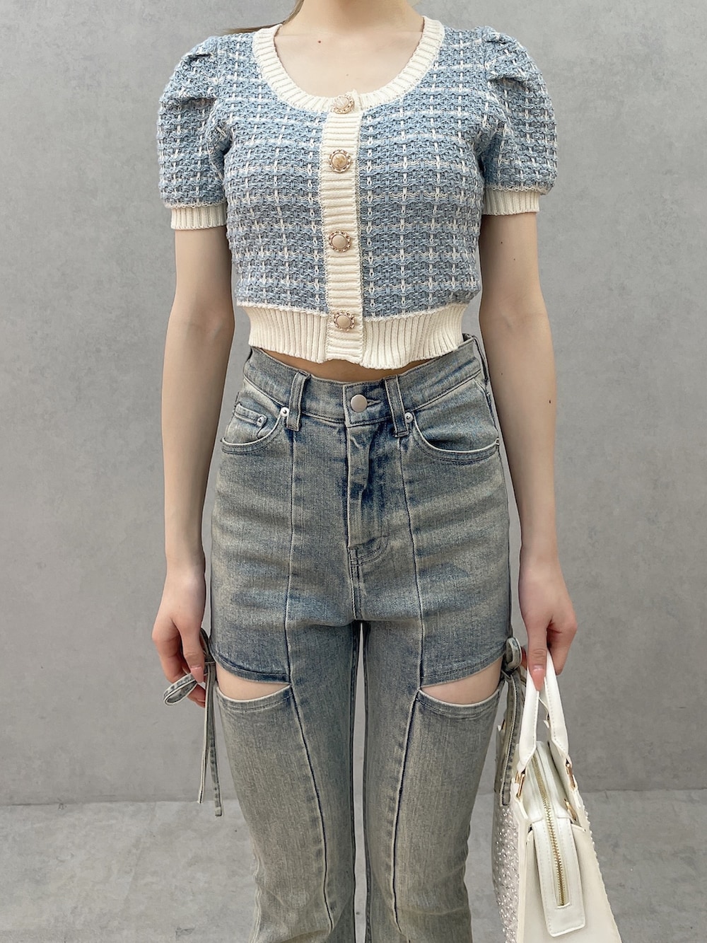 ブルー系のニット/セーター、ホワイト系のハンドバッグ、ホワイト系のサンダルを着用したレディースの春コーディネートの4枚目の写真