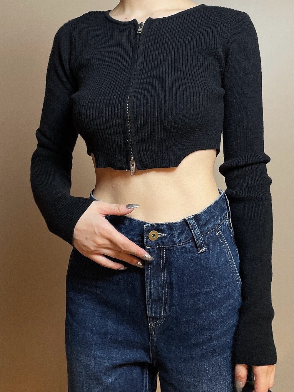 ブラック系のニット/セーター、ブルー系のデニムパンツ、ブラック系のハンドバッグを着用したレディースの冬コーディネートの7枚目の写真