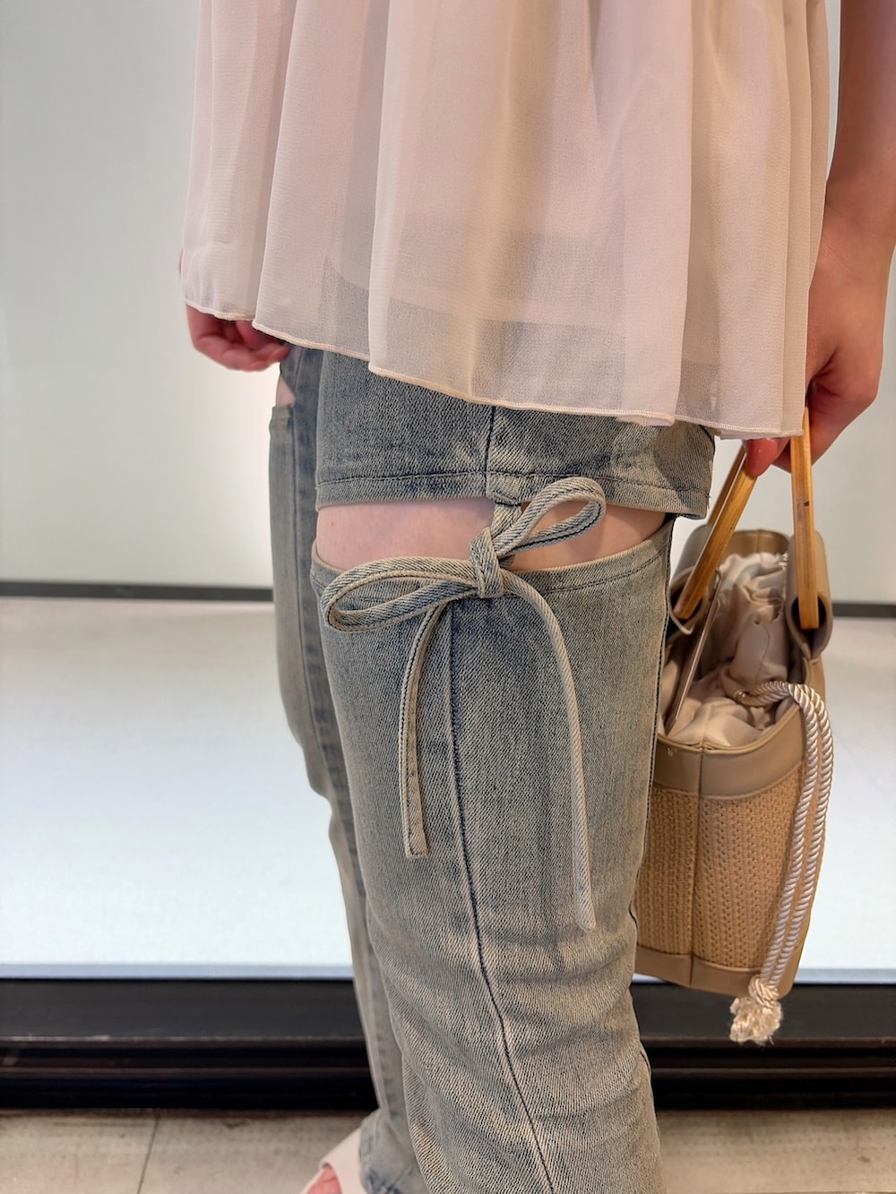 ホワイト系のシャツ/ブラウス、ブルー系のデニムパンツ、ベージュ系のハンドバッグを着用したレディースの夏コーディネートの5枚目の写真
