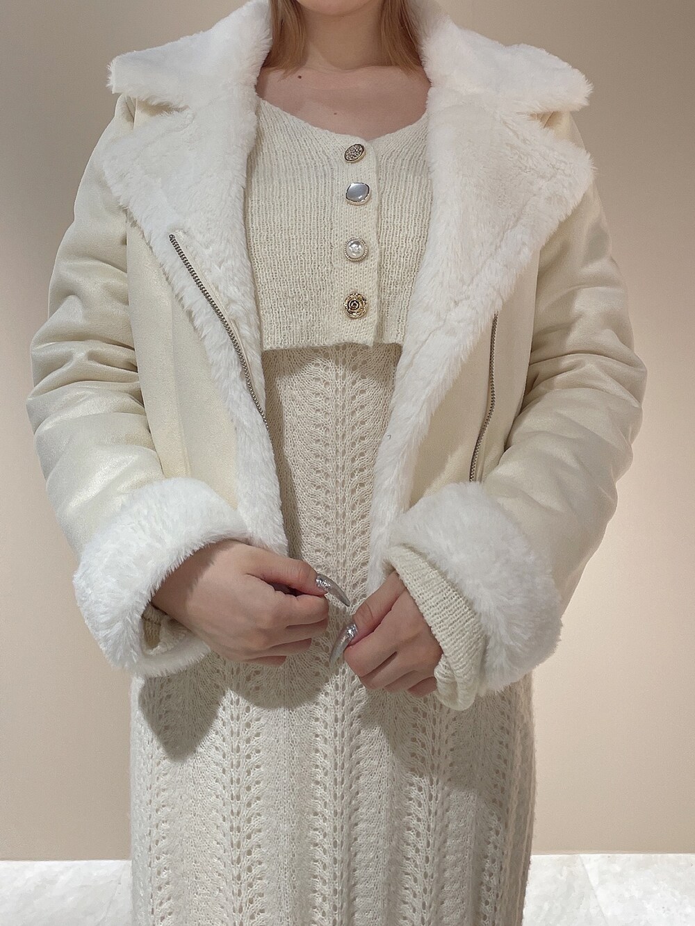 ホワイト系のブルゾン、ホワイト系のワンピース、ベージュ系のブーツを着用したレディースの秋コーディネートの7枚目の写真