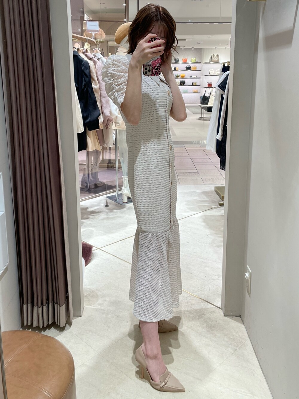 ホワイト系のワンピース、ベージュ系のパンプスを着用したレディースの春コーディネートの3枚目の写真