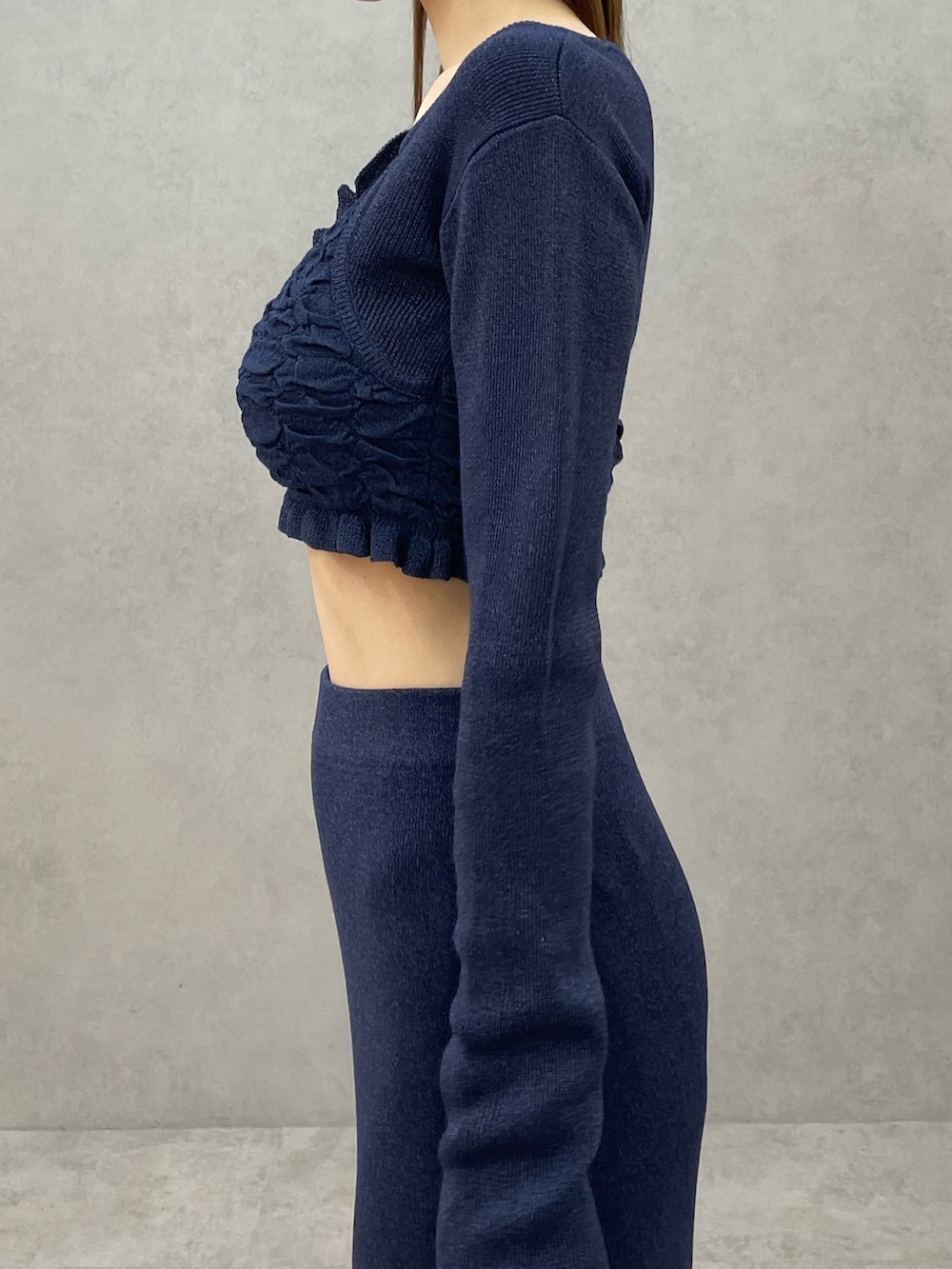 ブルー系のニット/セーター、ブルー系のスカート、ホワイト系のハンドバッグを着用したレディースの春コーディネートの7枚目の写真