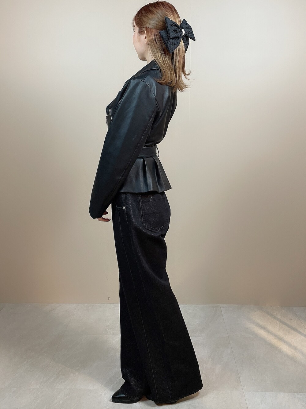 ブラック系のライダースジャケット、ブラック系のデニムパンツ、ブラック系のパンプスを着用したレディースの冬コーディネートの3枚目の写真