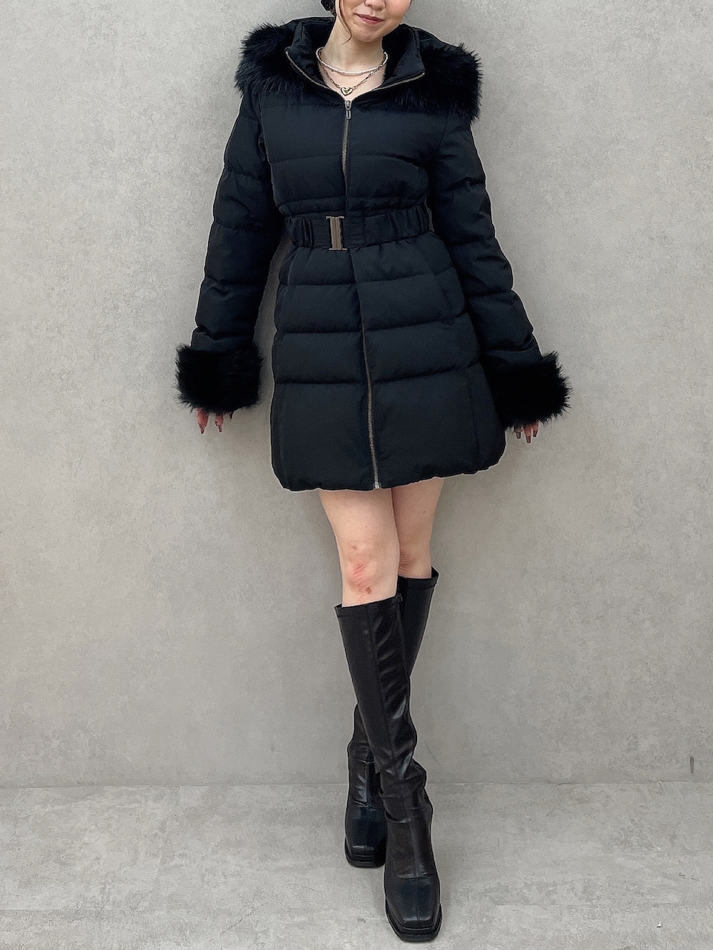 ブラック系のダウンジャケット/コート、ブラック系のニット/セーター、ブラック系のスカートを着用したレディースの夏コーディネートの2枚目の写真