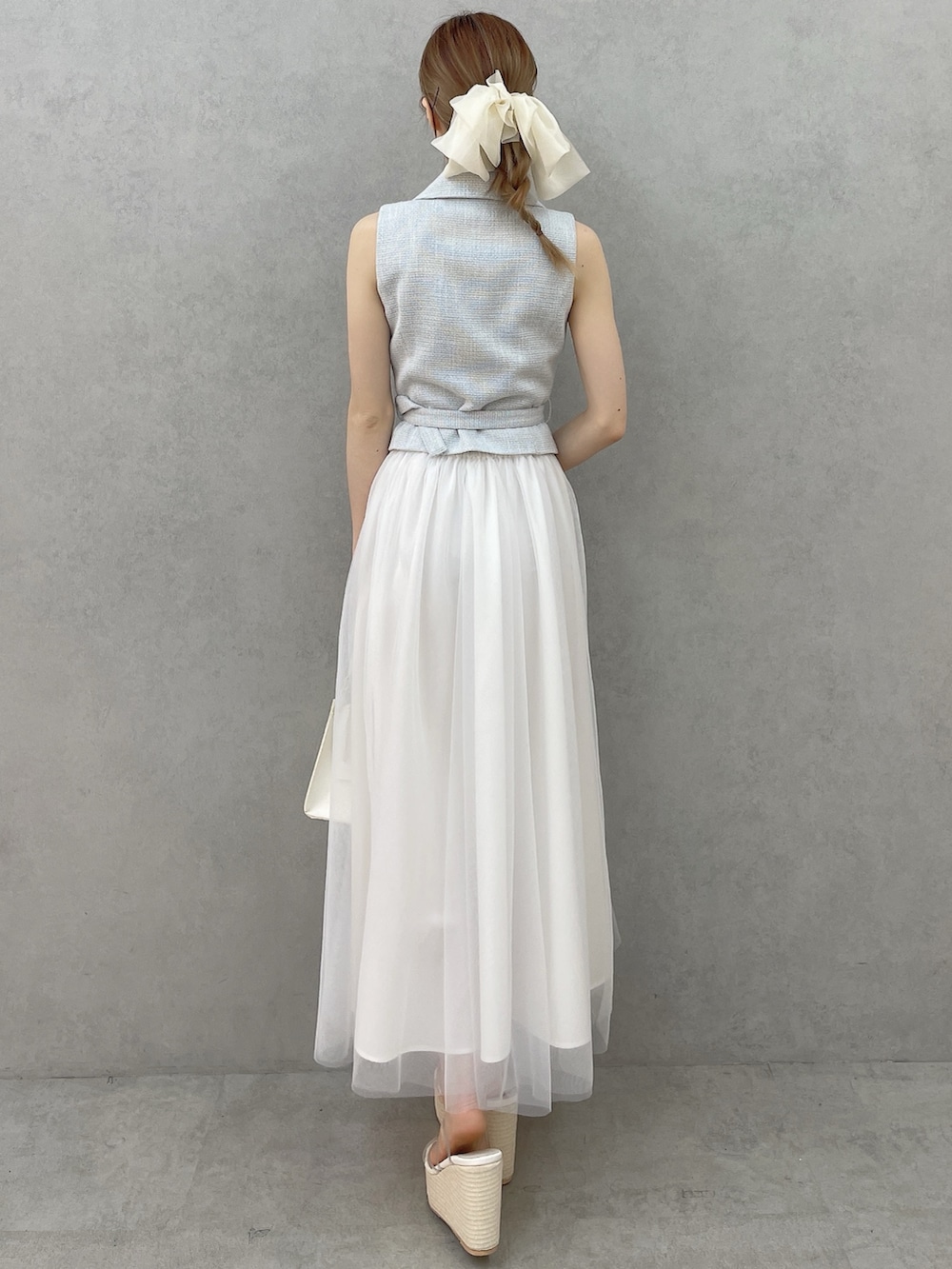 ブルー系のワンピース、ホワイト系のハンドバッグ、ホワイト系のサンダルを着用したレディースの春コーディネートの4枚目の写真