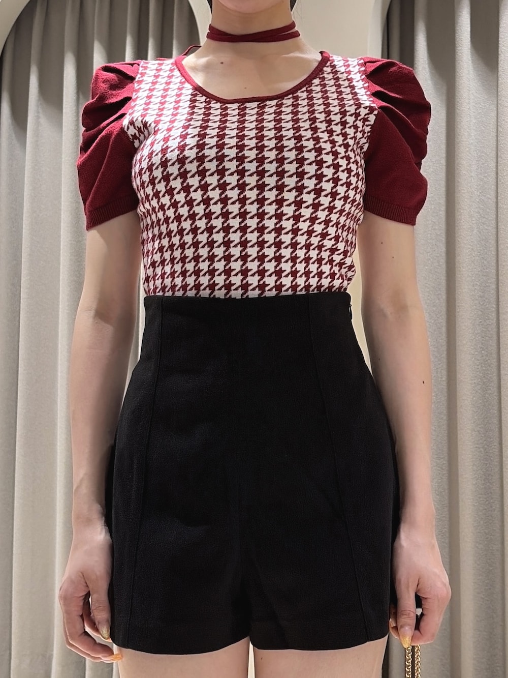 レッド系のニット/セーター、ブラック系のその他パンツ、ブラック系のハンドバッグを着用したレディースの夏コーディネートの4枚目の写真