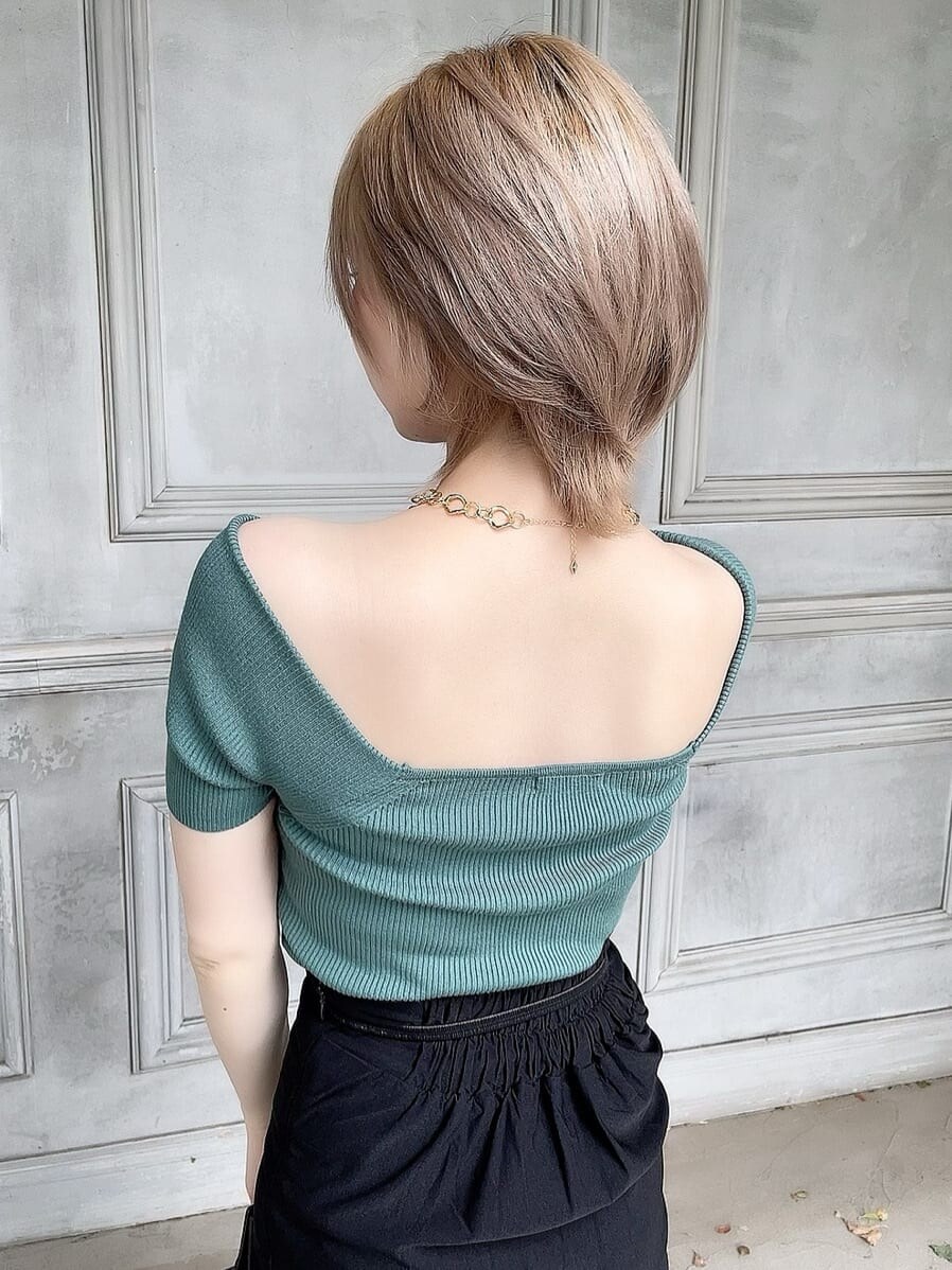 ブラック系のスカート、ブラック系のサンダル、グリーン系のニット/セーターを着用したレディースの春コーディネートの5枚目の写真