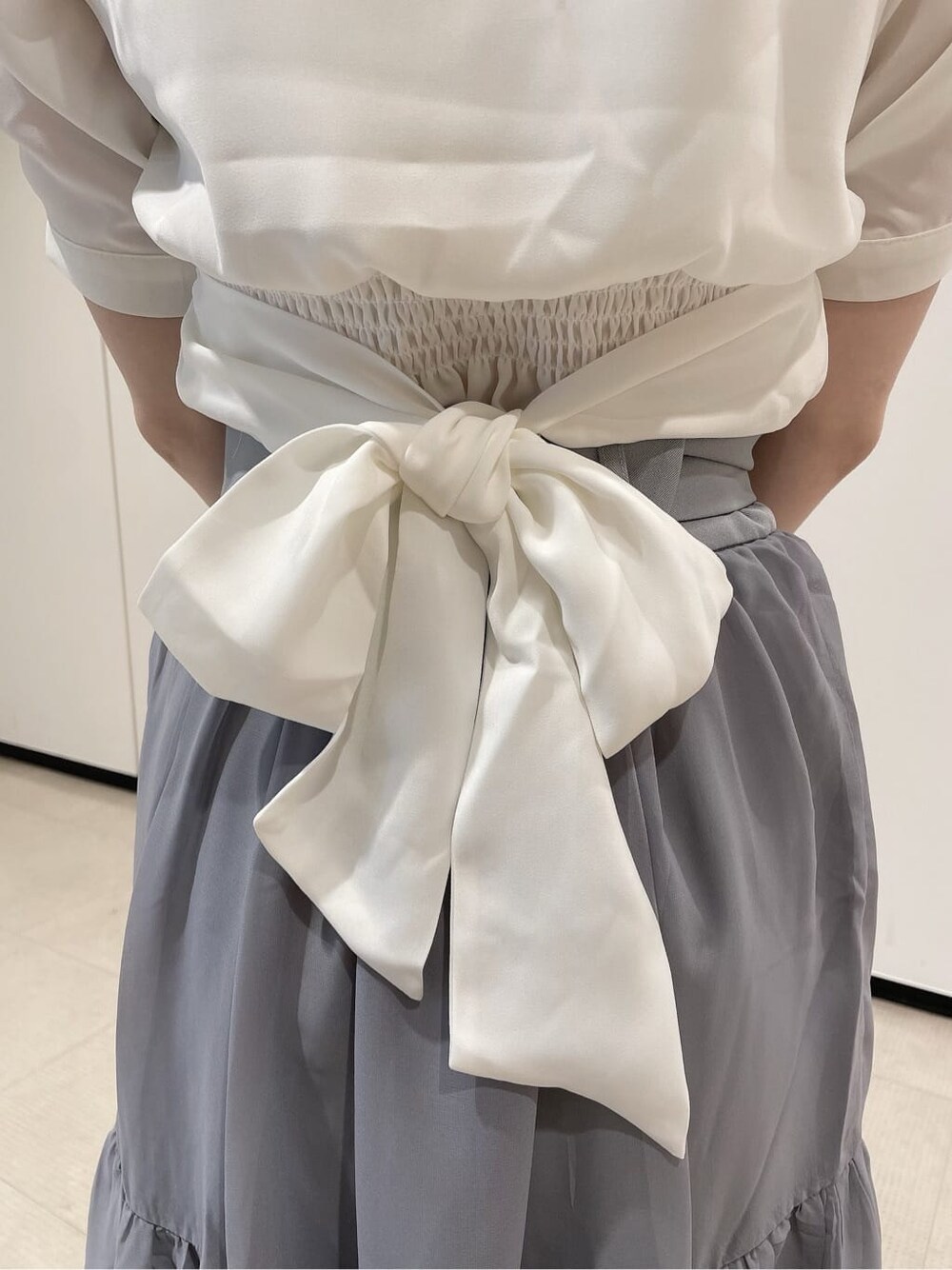 ホワイト系のパンプス、ホワイト系のシャツ/ブラウス、ブルー系のスカートを着用したレディースの夏コーディネートの8枚目の写真