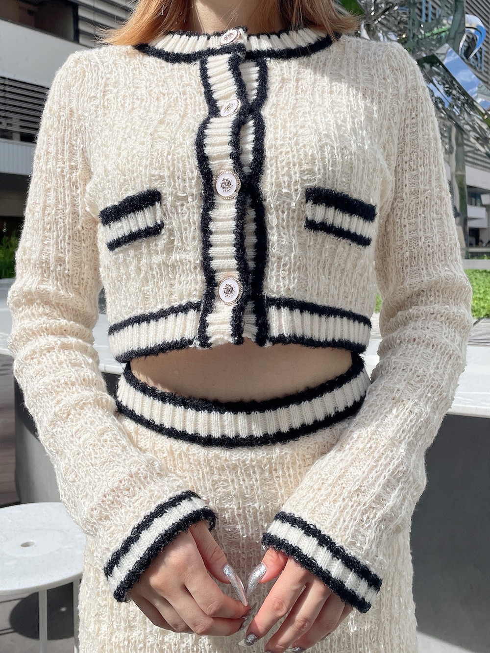 ホワイト系のカーディガン/ボレロ、ホワイト系のスカート、ブラック系のブーツを着用したレディースの秋コーディネートの5枚目の写真