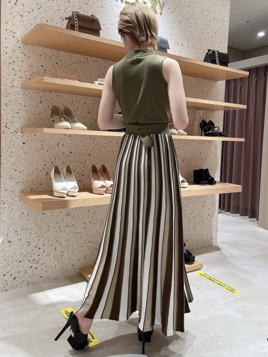 ブラック系のサンダル、グリーン系のワンピース、シルバー系のネックレスを着用したレディースの夏コーディネートの2枚目の写真