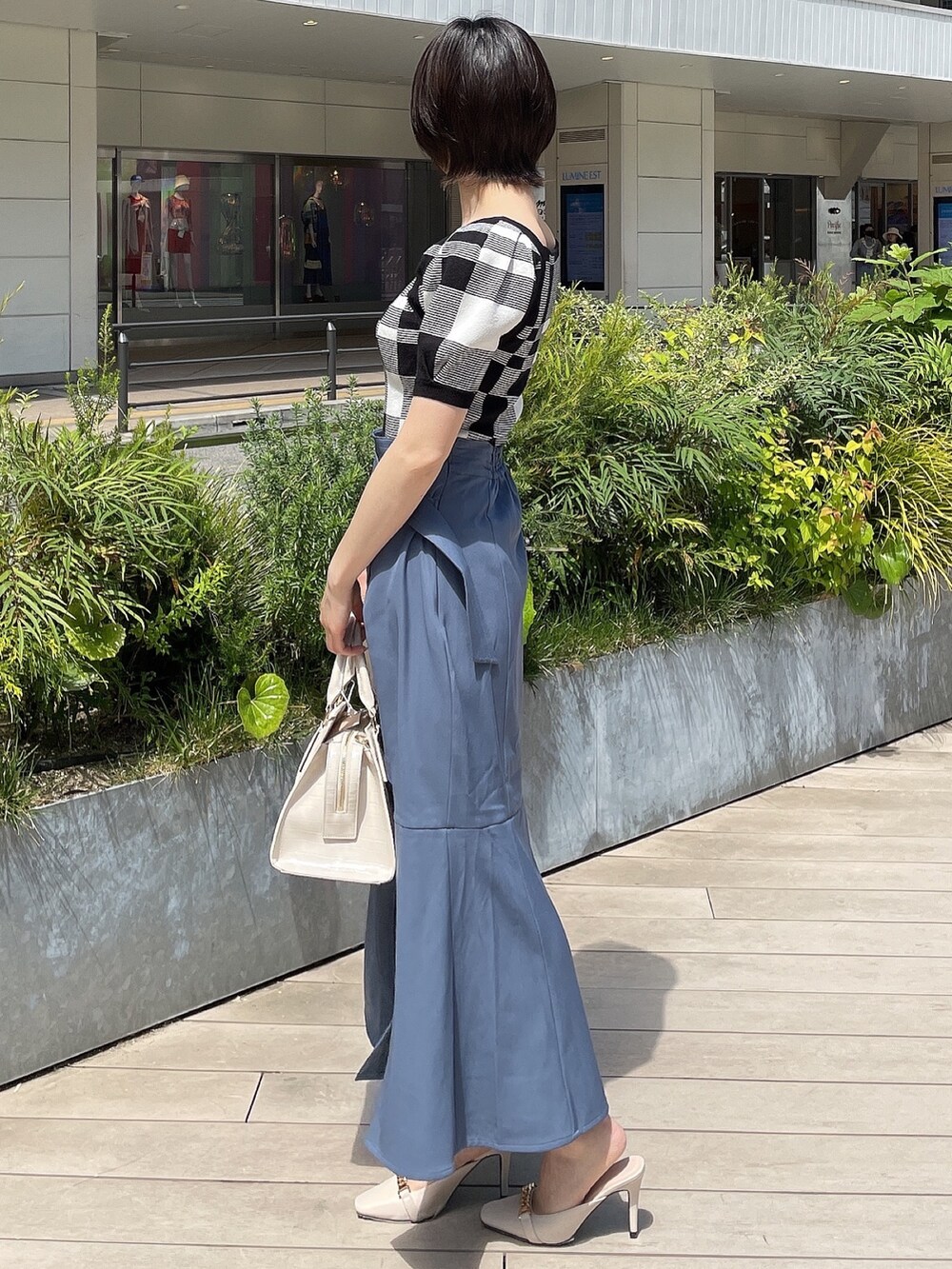 その他のニット/セーター、ブルー系のスカート、ホワイト系のハンドバッグを着用したレディースの春コーディネートの2枚目の写真