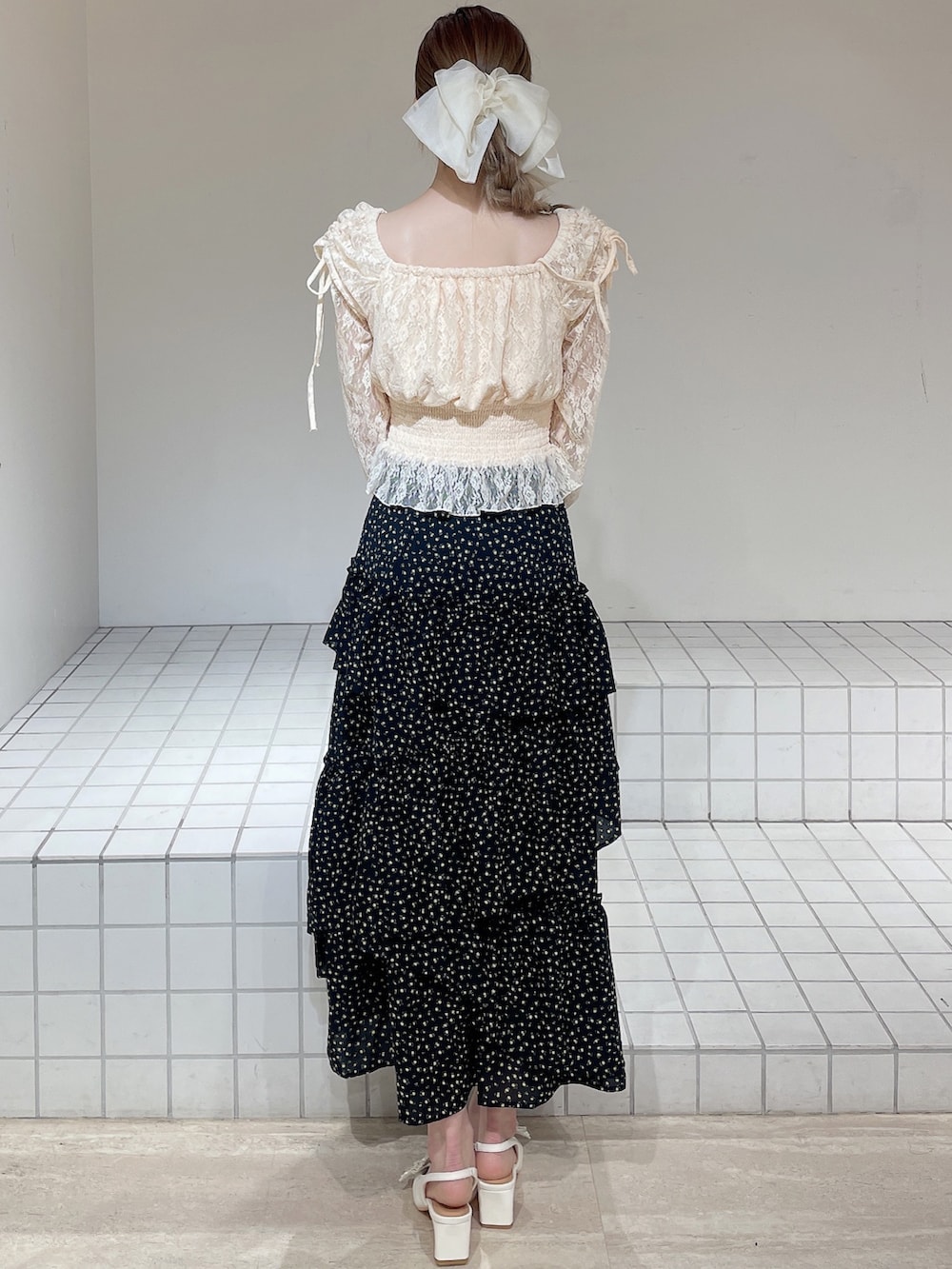 オレンジ系のシャツ/ブラウス、ブラック系のスカート、ホワイト系のパンプスを着用したレディースの春コーディネートの4枚目の写真