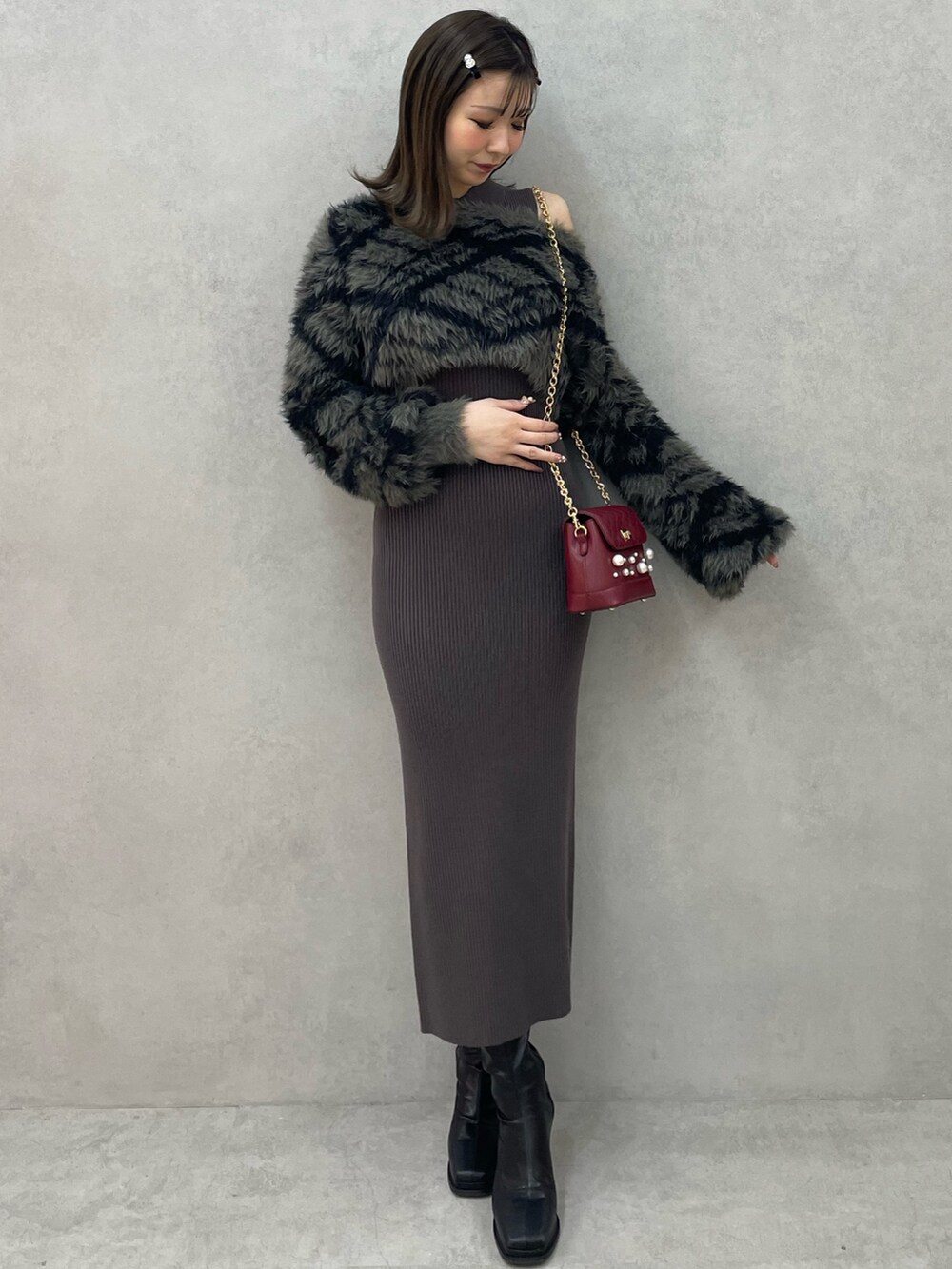 グレー系のワンピース、レッド系のショルダーバッグ、ブラック系のブーツを着用したレディースの秋コーディネートの2枚目の写真