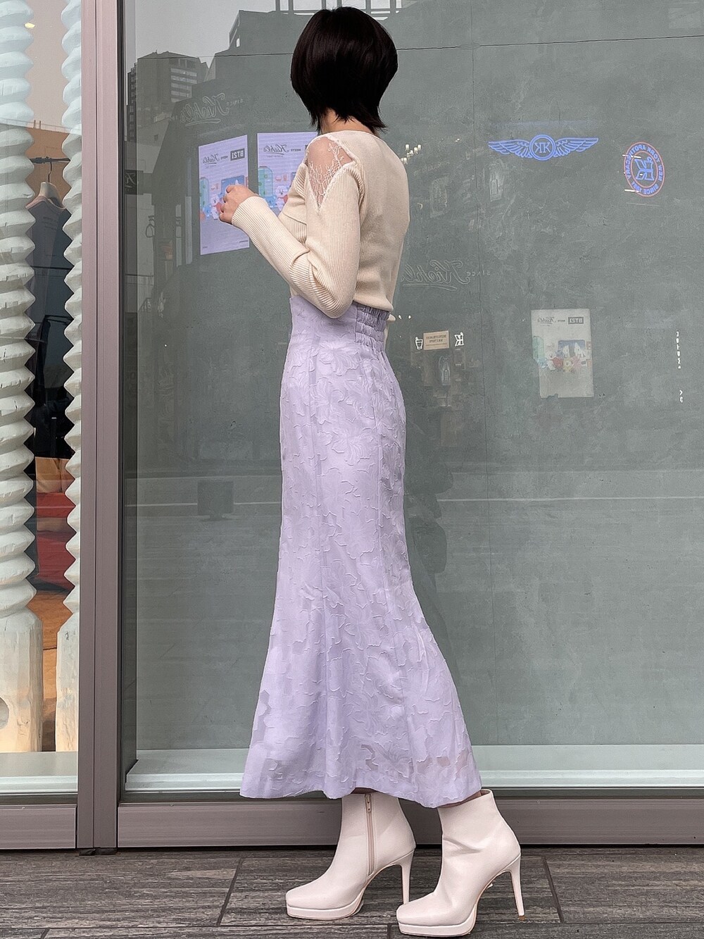 ホワイト系のブーツ、ブラウン系のハンドバッグ、ホワイト系のニット/セーターを着用したレディースの冬コーディネートの3枚目の写真