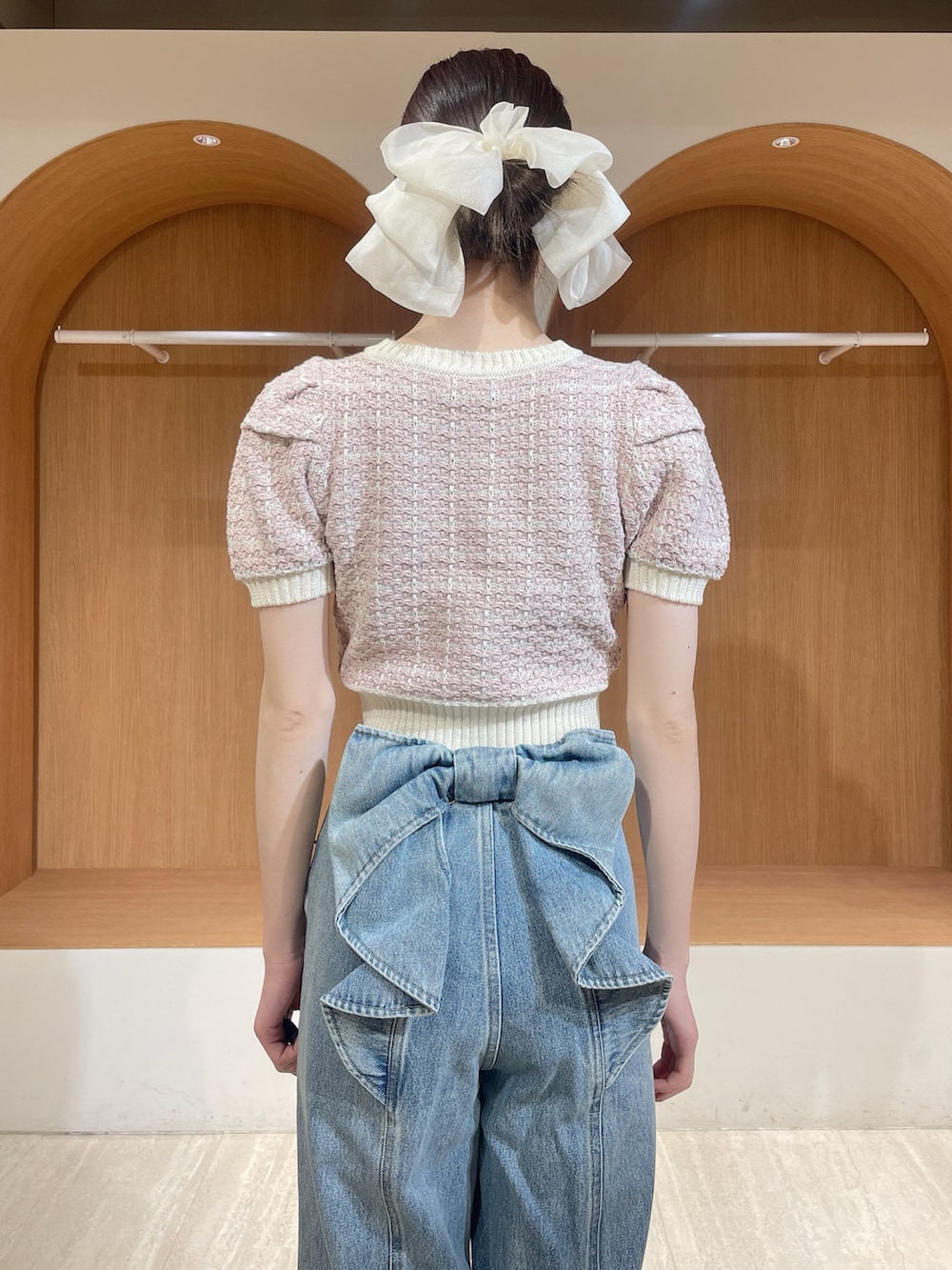 ピンク系のニット/セーター、ブルー系のデニムパンツ、ホワイト系のサンダルを着用したレディースの春コーディネートの6枚目の写真