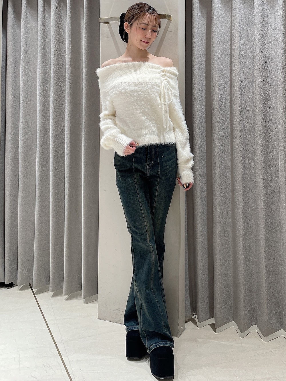ホワイト系のニット/セーター、ブルー系のデニムパンツ、ブラック系のブーツを着用したレディースの秋コーディネートの2枚目の写真