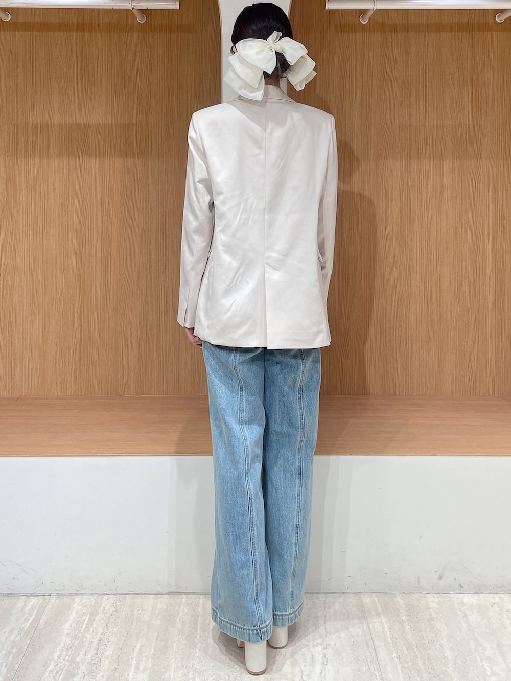 ホワイト系のテーラードジャケット、イエロー系のカーディガン/ボレロ、ブルー系のデニムパンツを着用したレディースの春コーディネートの4枚目の写真