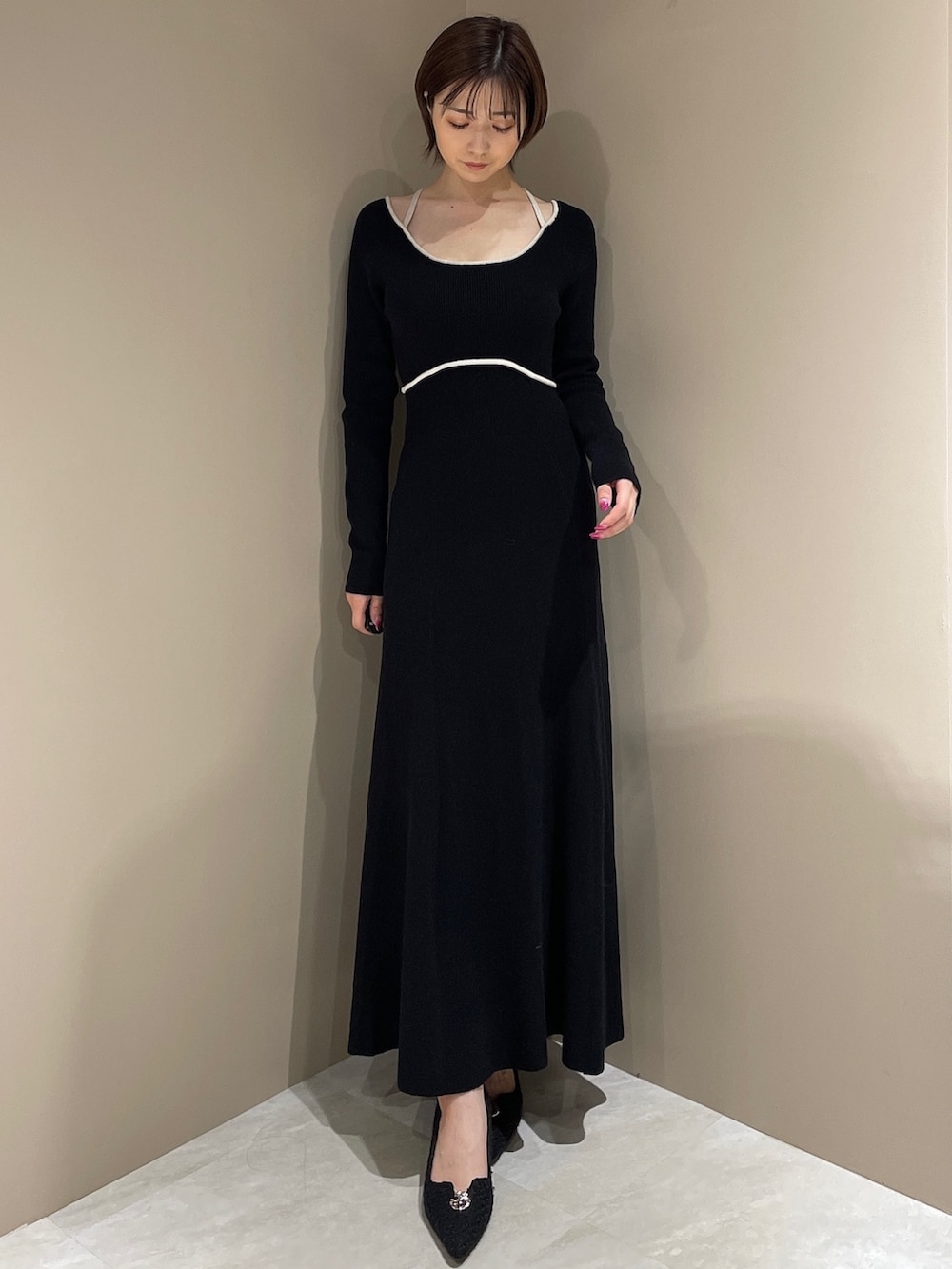 ブラック系のブーツ、ブラック系のワンピース、ホワイト系のダウンジャケット/コートを着用したレディースの夏コーディネートの10枚目の写真