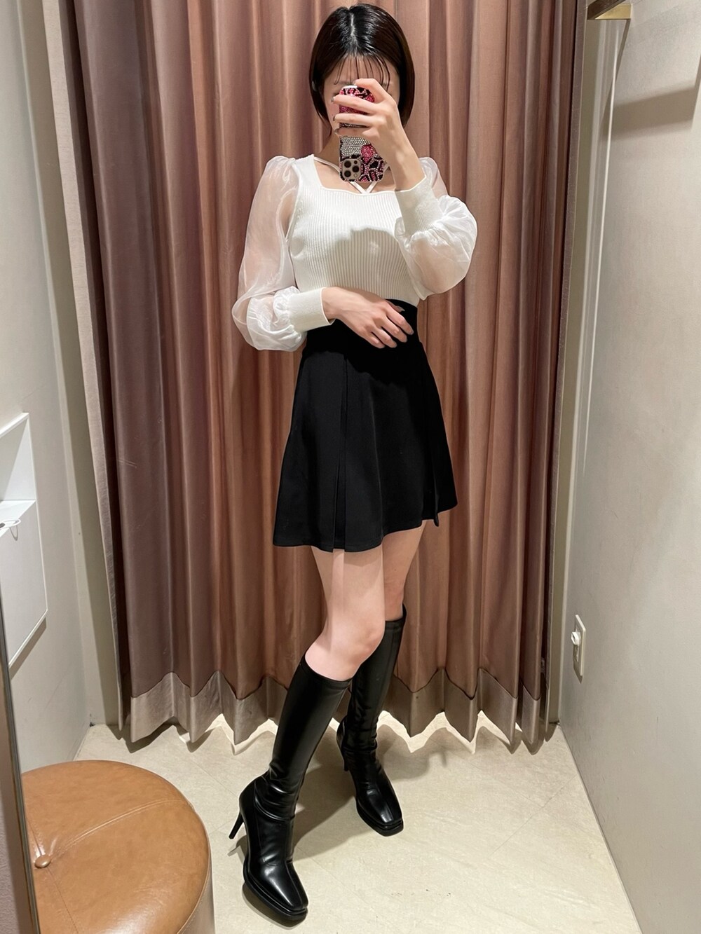 ホワイト系のニット/セーター、ブラック系のスカート、ブラック系のブーツを着用したレディースの冬コーディネートの3枚目の写真