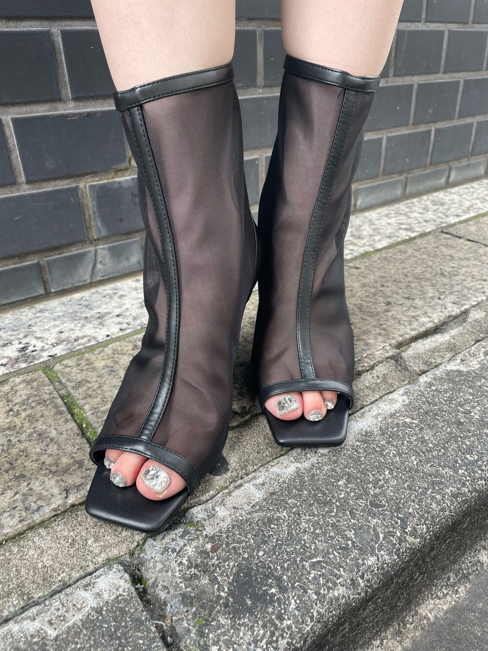 グレー系のワンピース、ブラック系のブーツ、ブラック系のハットを着用したレディースの夏コーディネートの3枚目の写真