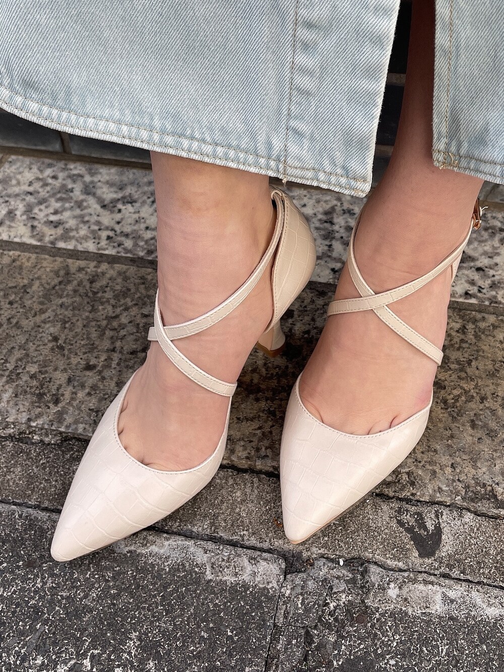 ホワイト系のワンピース、ブラック系のハンドバッグ、ホワイト系のパンプスを着用したレディースの春コーディネートの7枚目の写真