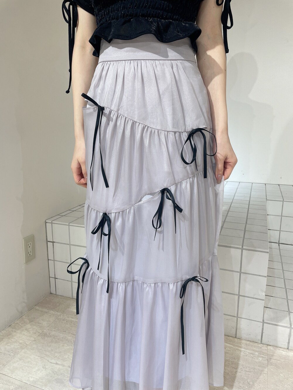 ブラック系のTシャツ/カットソー、ブルー系のスカート、ブラック系のパンプスを着用したレディースの夏コーディネートの6枚目の写真