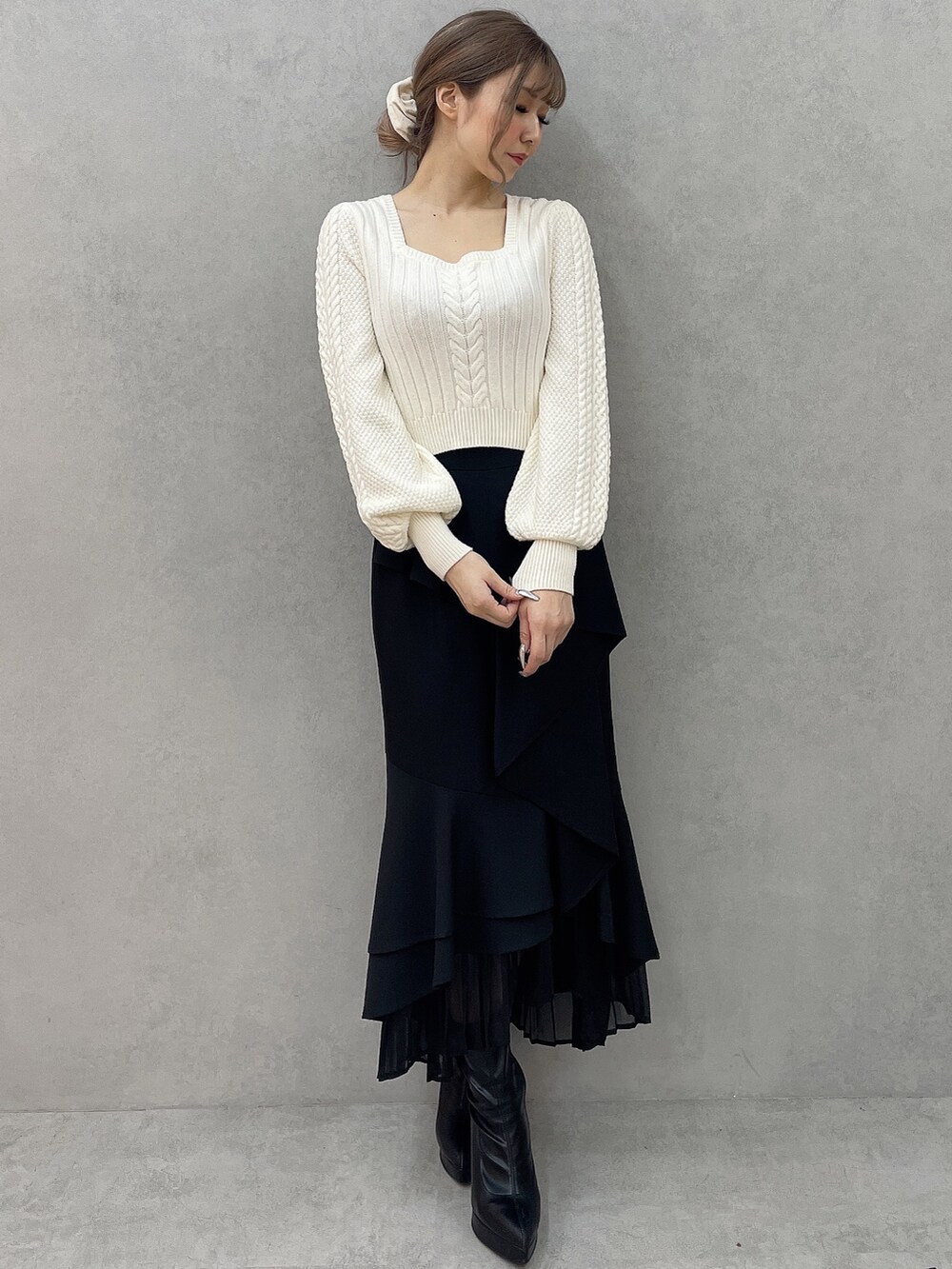ホワイト系のダウンジャケット/コート、ホワイト系のニット/セーター、ブラック系のスカートを着用したレディースの秋コーディネートの8枚目の写真