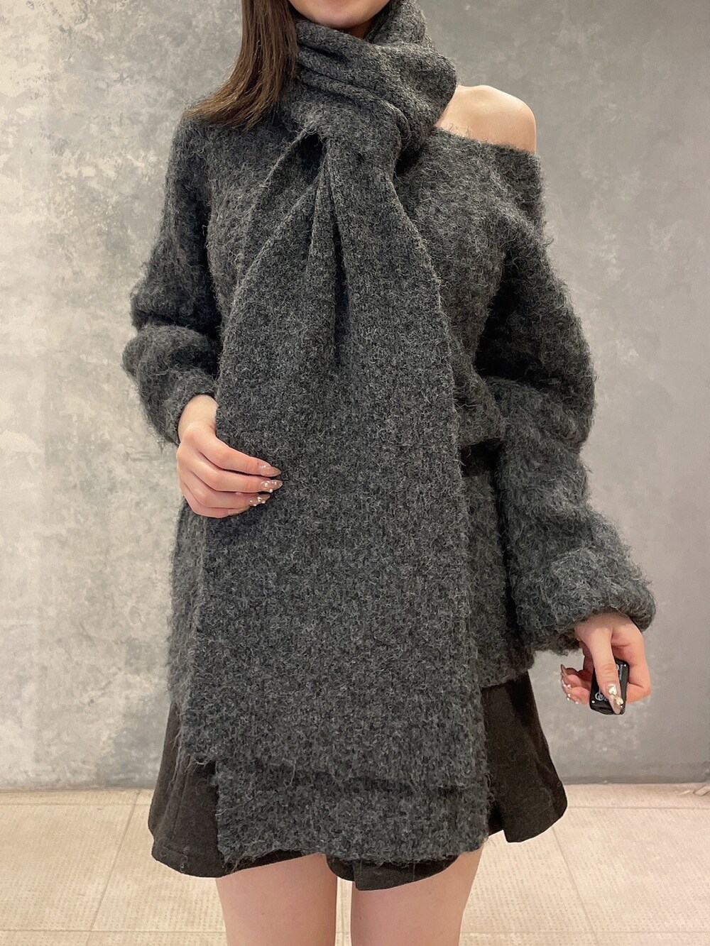 グレー系のワンピース、グレー系のスカート、ブラック系のブーツを着用したレディースの秋コーディネートの6枚目の写真