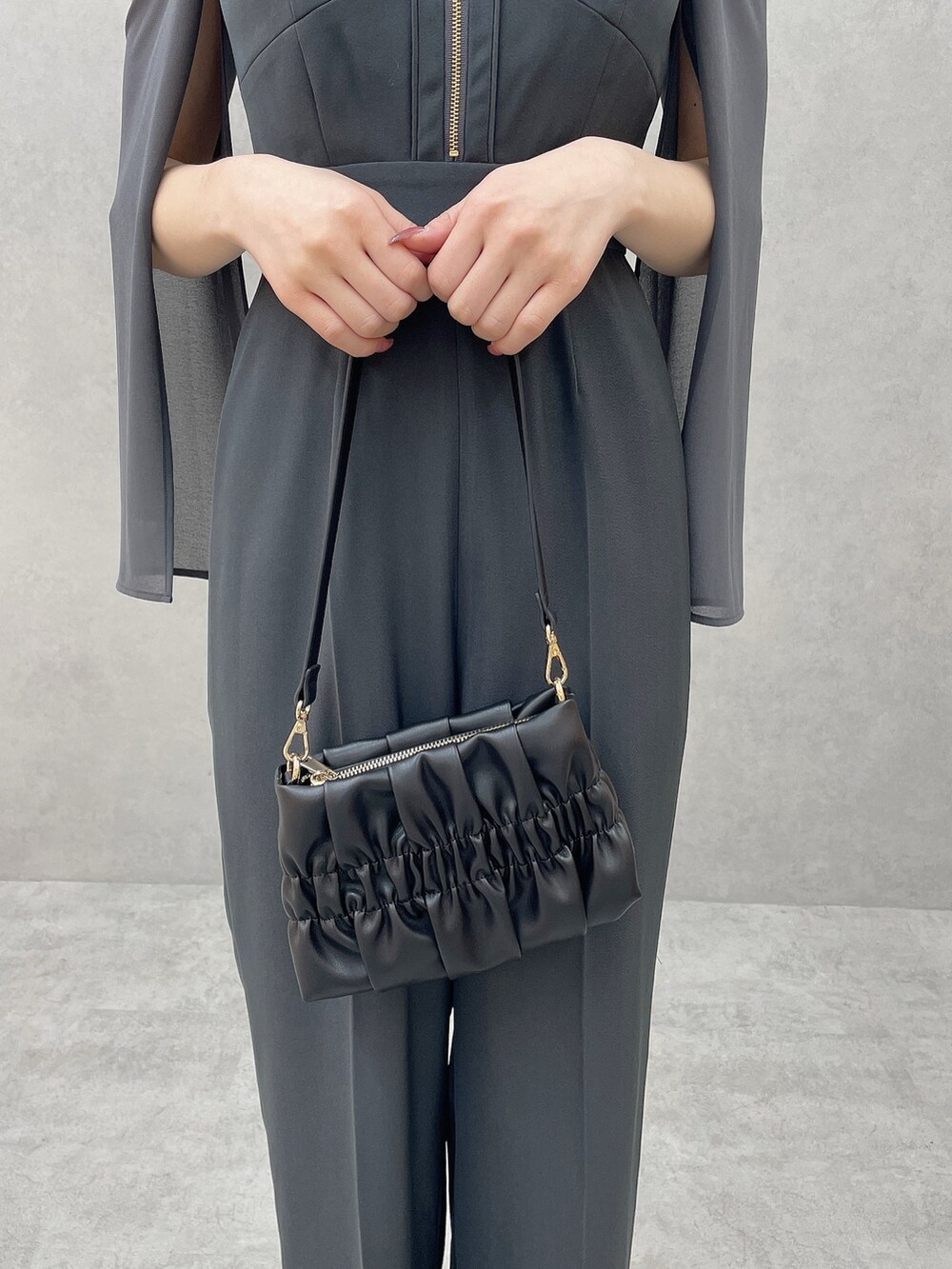 グレー系のつなぎ/オールインワン、ブラック系のハンドバッグ、ブラック系のパンプスを着用したレディースの冬コーディネートの9枚目の写真