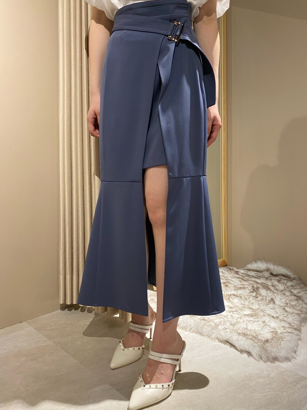 ホワイト系のニット/セーター、ブルー系のスカート、ホワイト系のパンプスを着用したレディースの春コーディネートの8枚目の写真