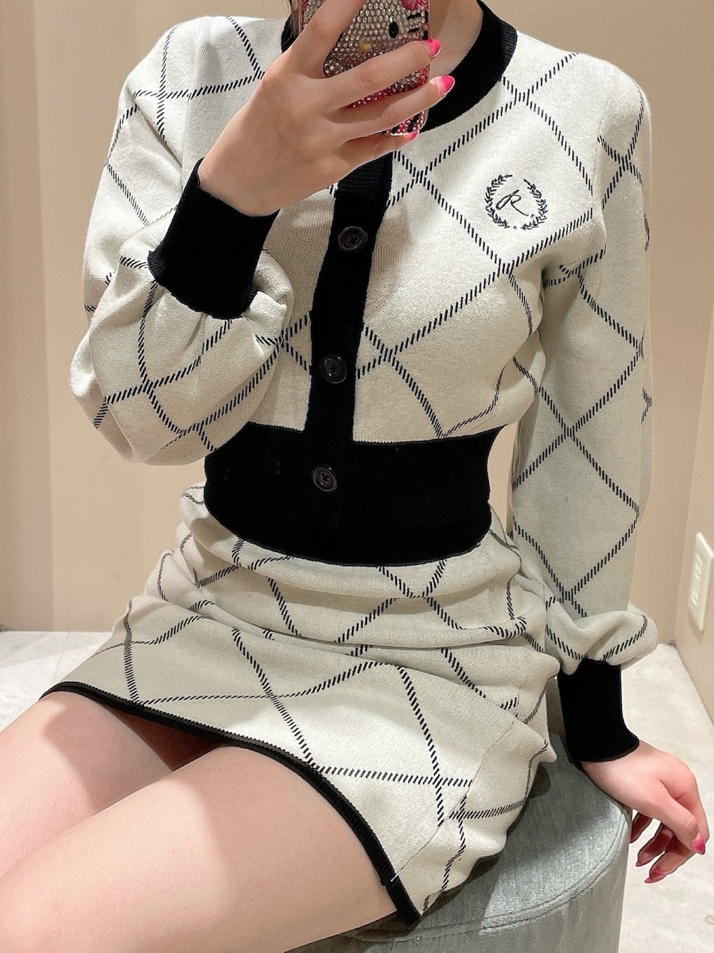 ホワイト系のカーディガン/ボレロ、ホワイト系のスカート、ブラック系のパンプスを着用したレディースの冬コーディネートの6枚目の写真