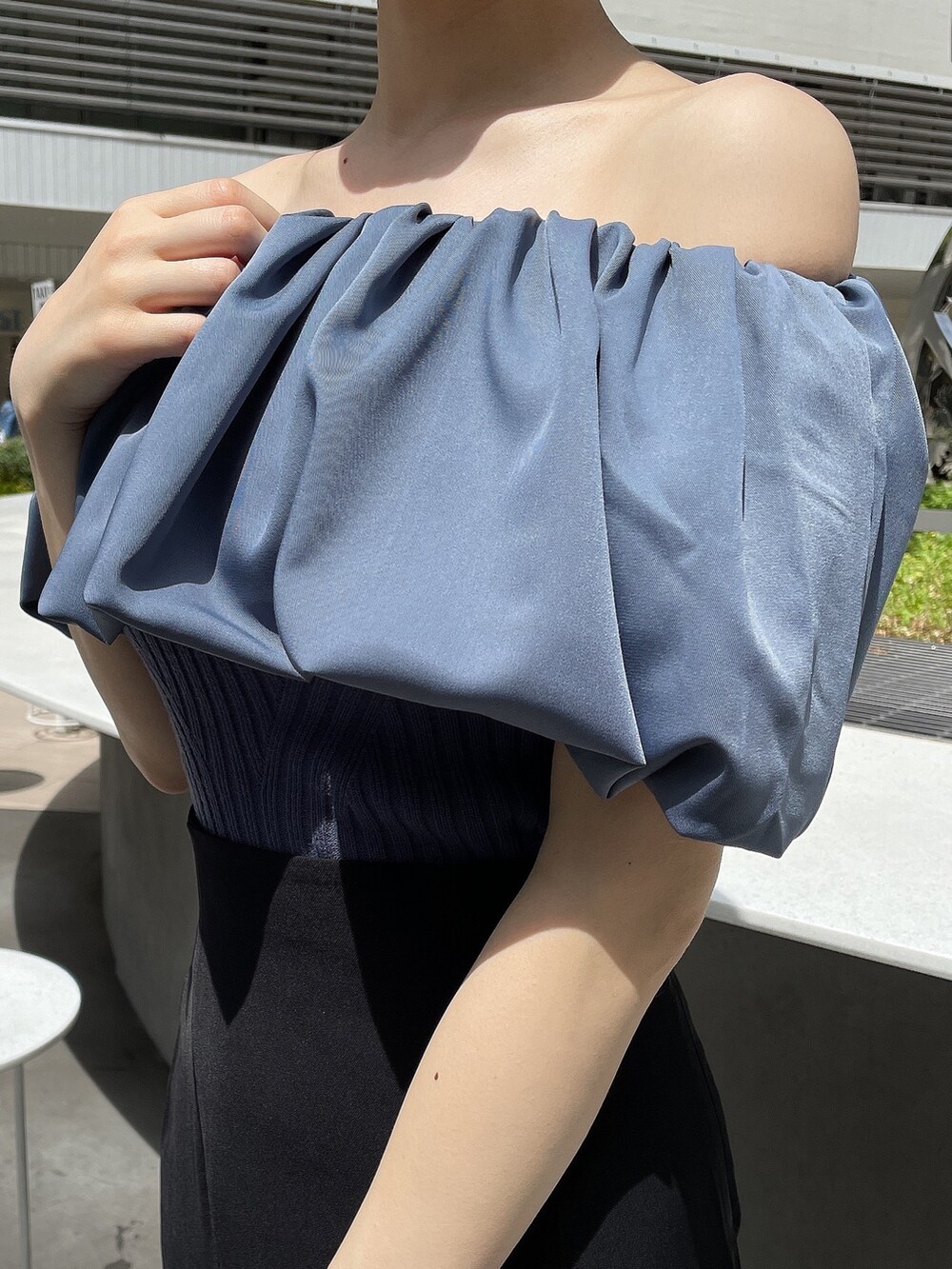 ブラック系のサンダル、ブルー系のニット/セーター、ブラック系のスカートを着用したレディースの春コーディネートの6枚目の写真