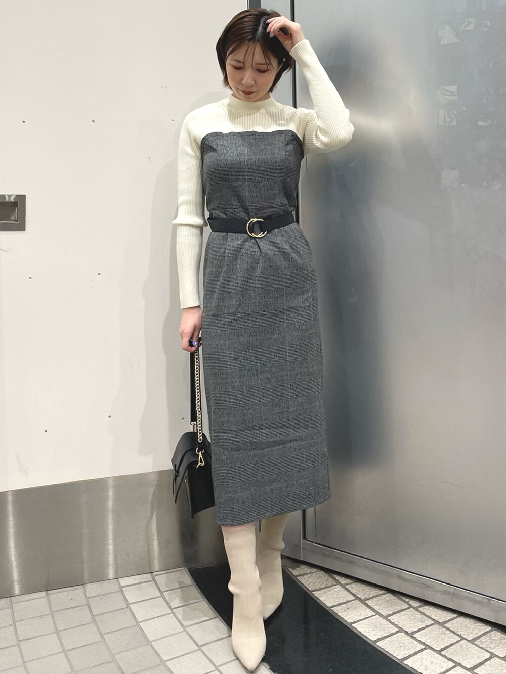 ホワイト系のブーツ、ブラック系のハンドバッグ、グレー系のその他アウターを着用したレディースの冬コーディネートの5枚目の写真