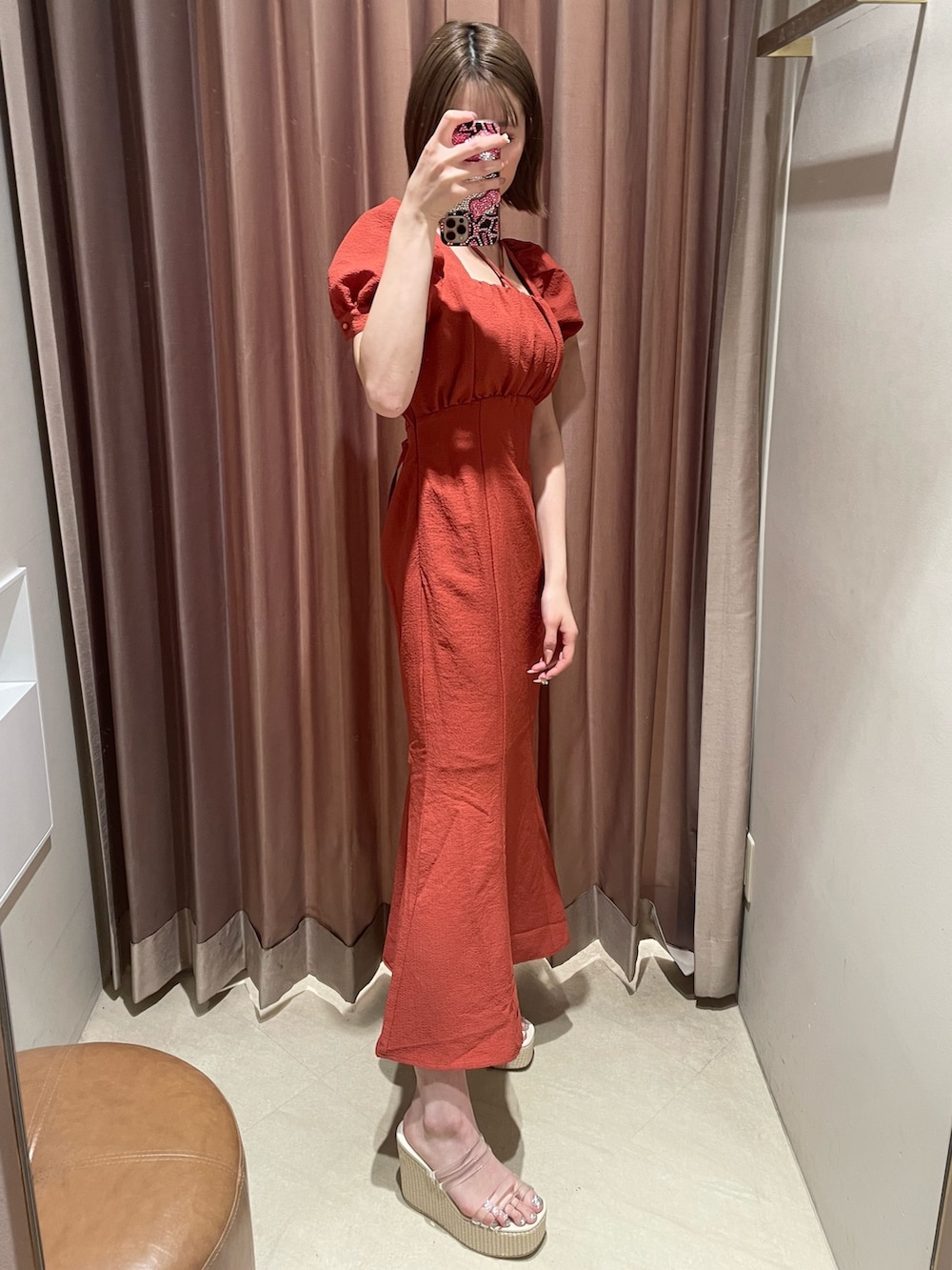 オレンジ系のワンピース、ホワイト系のサンダルを着用したレディースの春コーディネートの2枚目の写真