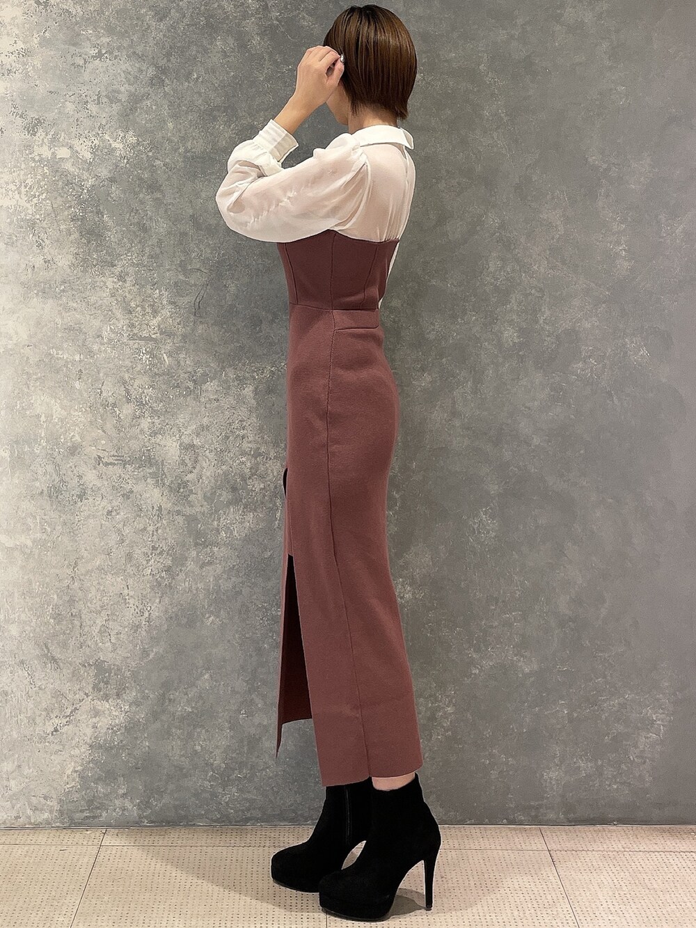 ブラック系のブーツ、ホワイト系のブルゾン、ブラウン系のワンピースを着用したレディースの秋コーディネートの6枚目の写真