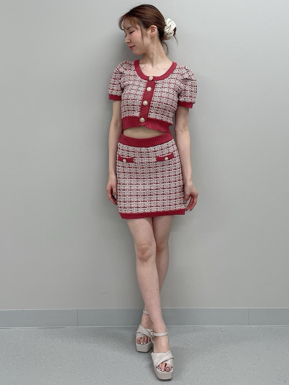 ピンク系のニット/セーター、ピンク系のスカート、ベージュ系のサンダルを着用したレディースの春コーディネートの2枚目の写真