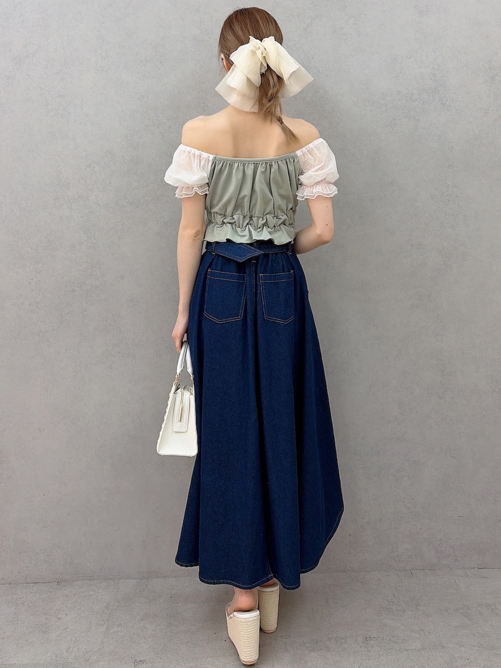 ホワイト系のハンドバッグ、グリーン系のシャツ/ブラウス、ブルー系のスカートを着用したレディースの春コーディネートの3枚目の写真