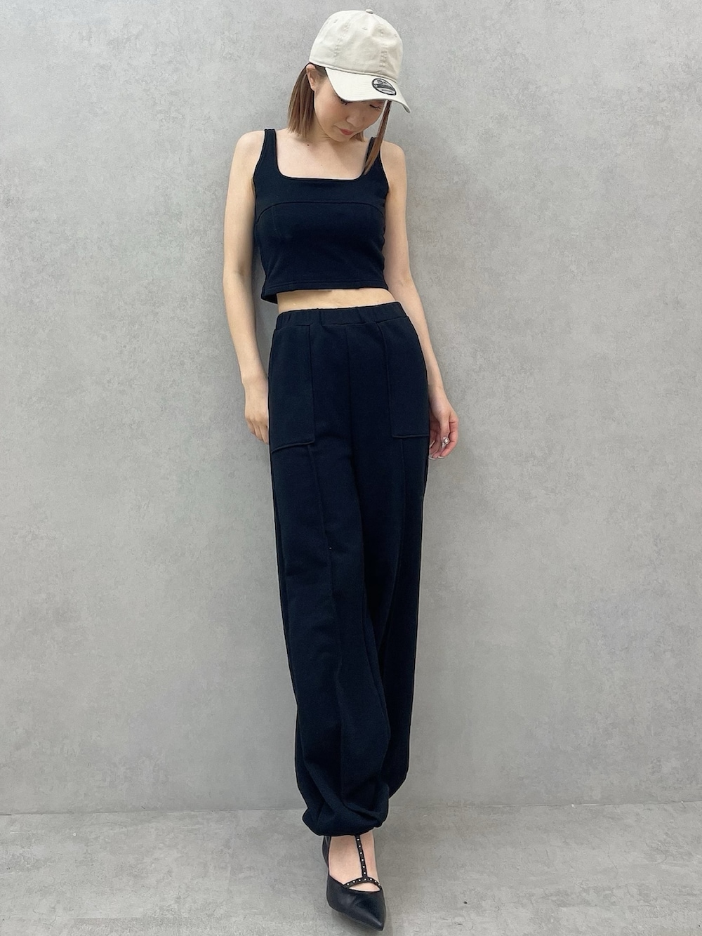 ブラック系のタンクトップ、ブラック系のスウェットパンツ、ブラック系のパンプスを着用したレディースの夏コーディネートの2枚目の写真